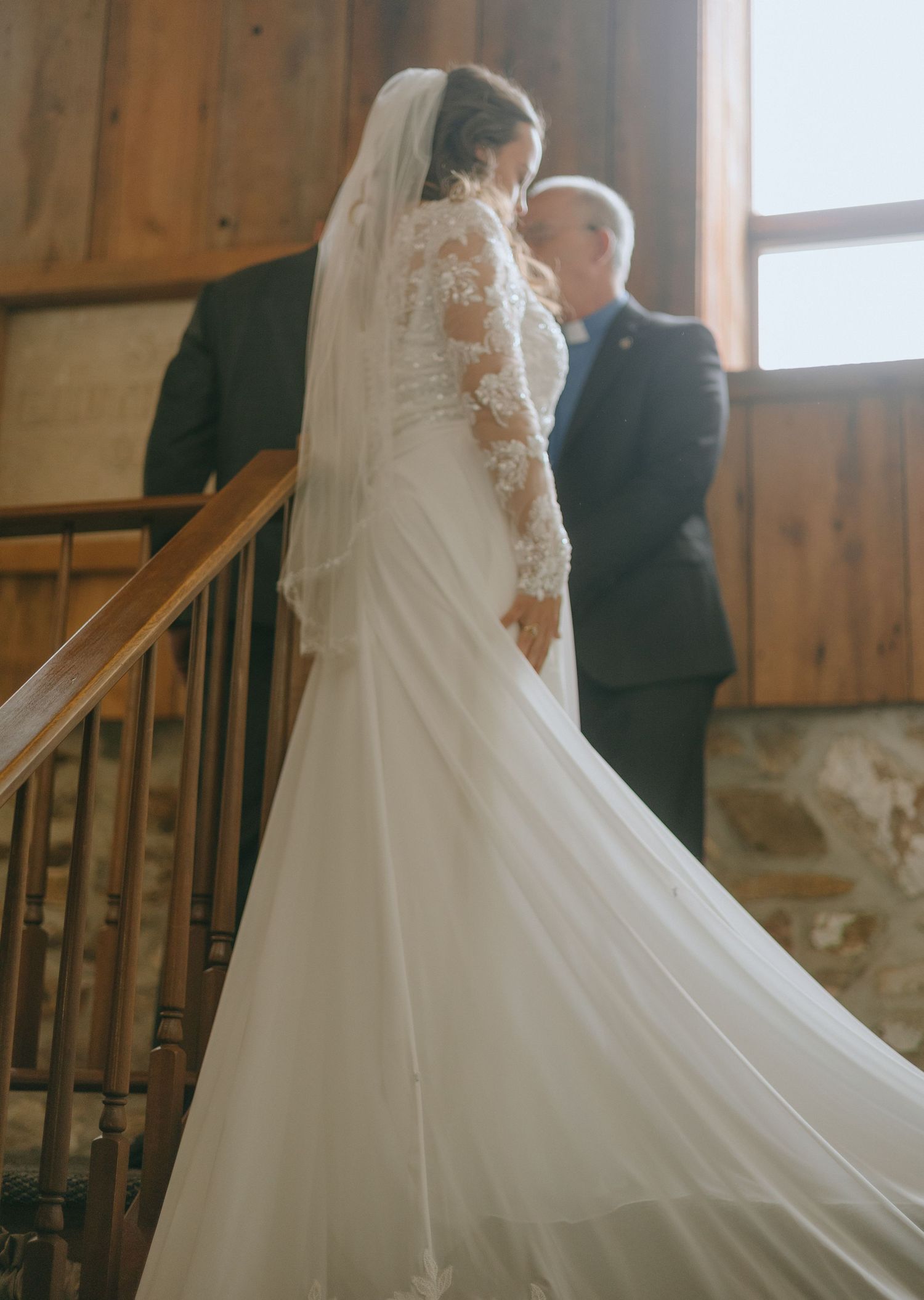 A series of wedding photos showing a couple walking up wooden stairs in a rustic venue with the bride's veil trailing behind.