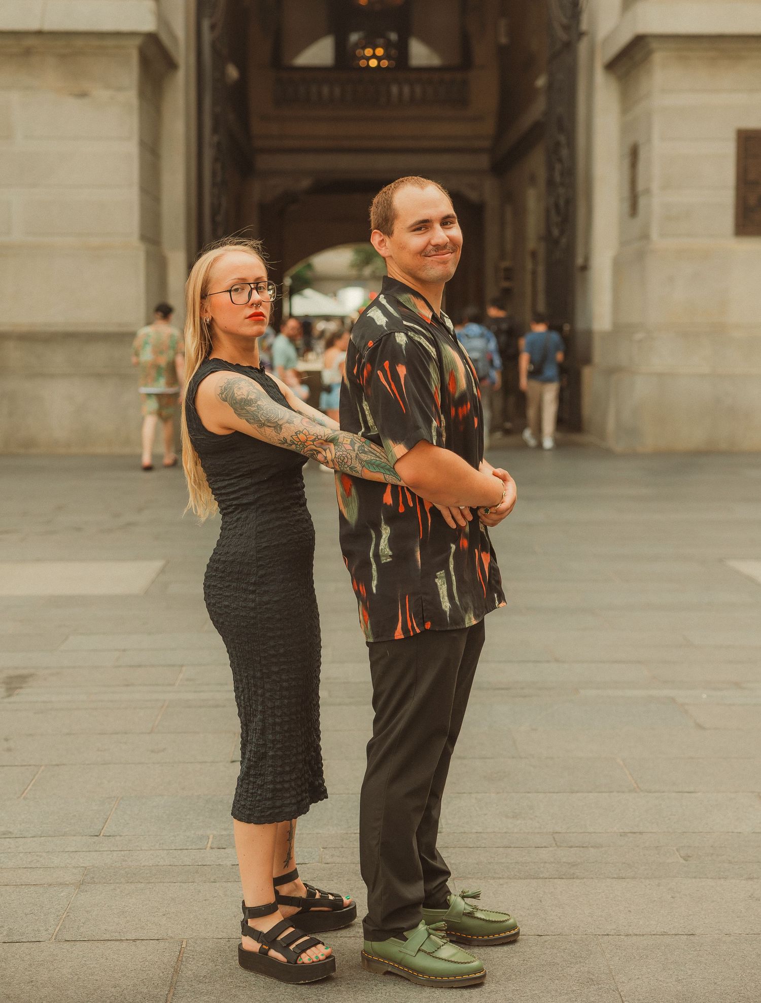 A couple dances playfully together on a stone plaza.