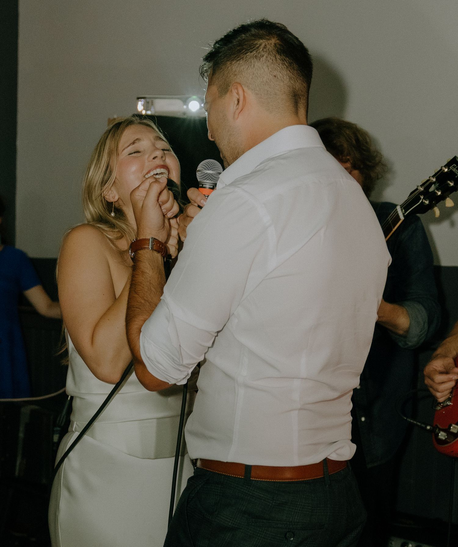 Candid moments of celebration and dancing at a dimly lit wedding reception.