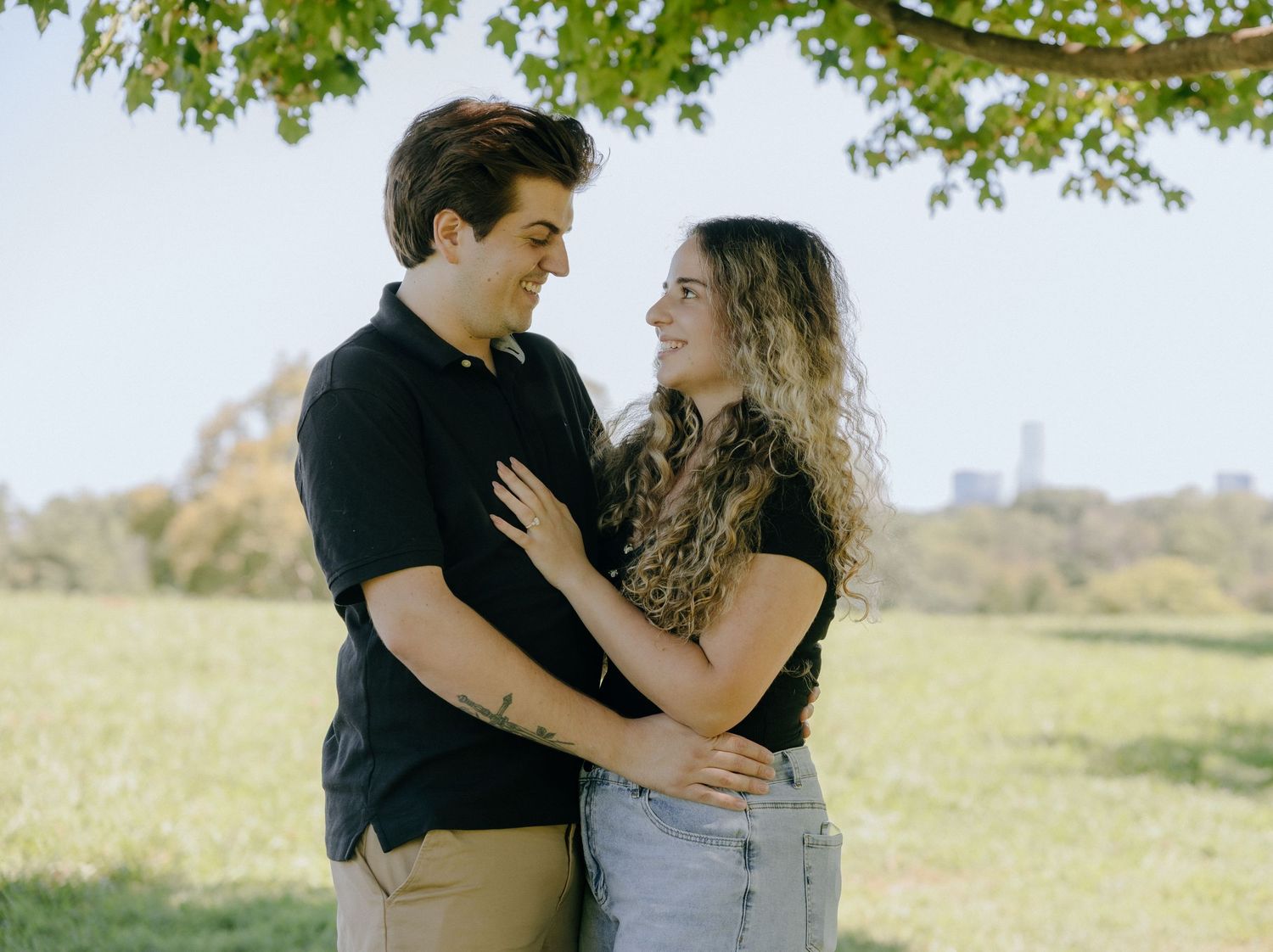 Couple enjoying a romantic outdoor picnic in a lush green field.