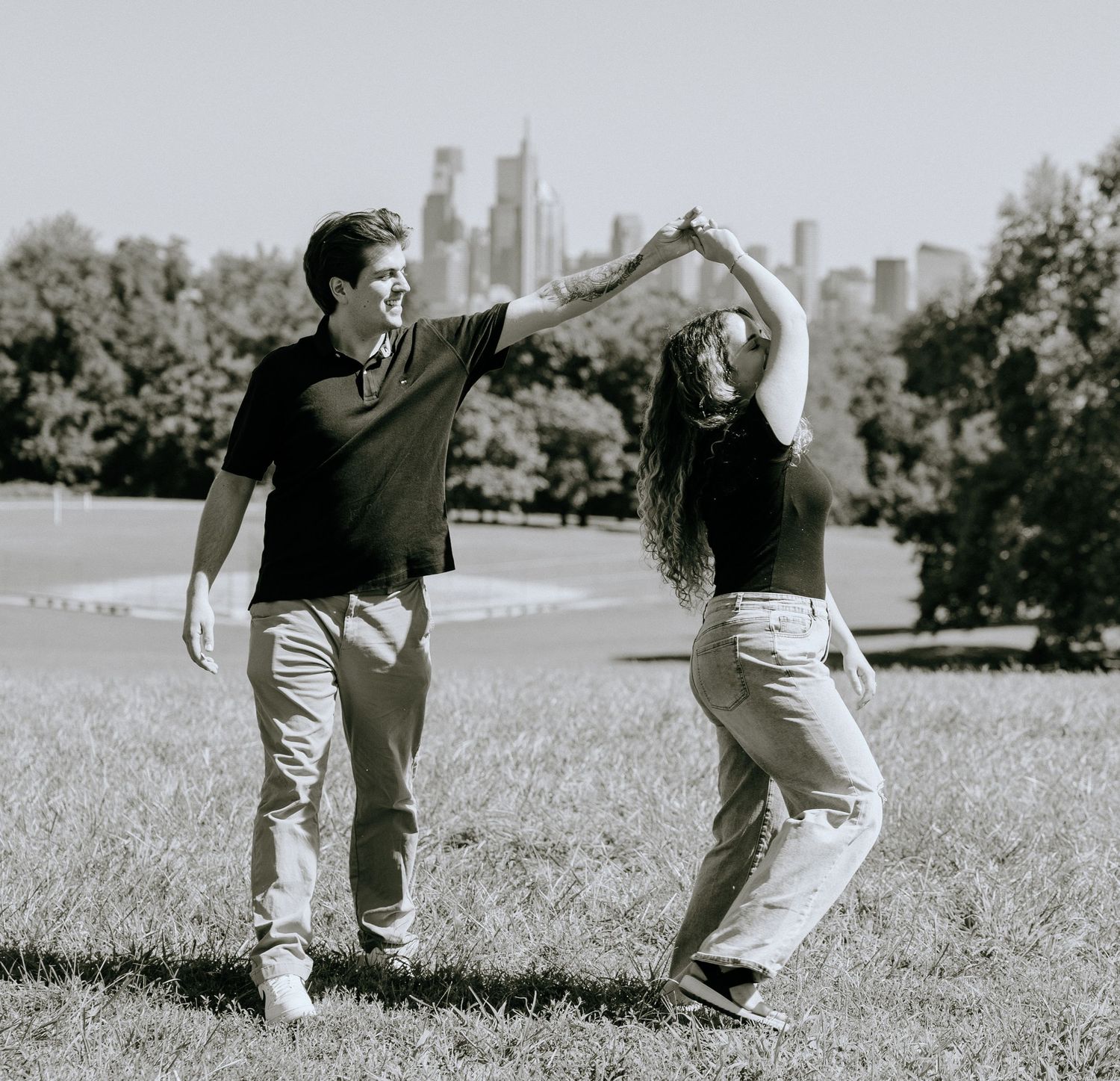 Playful movements captured in black and white photography on a grassy hillside.