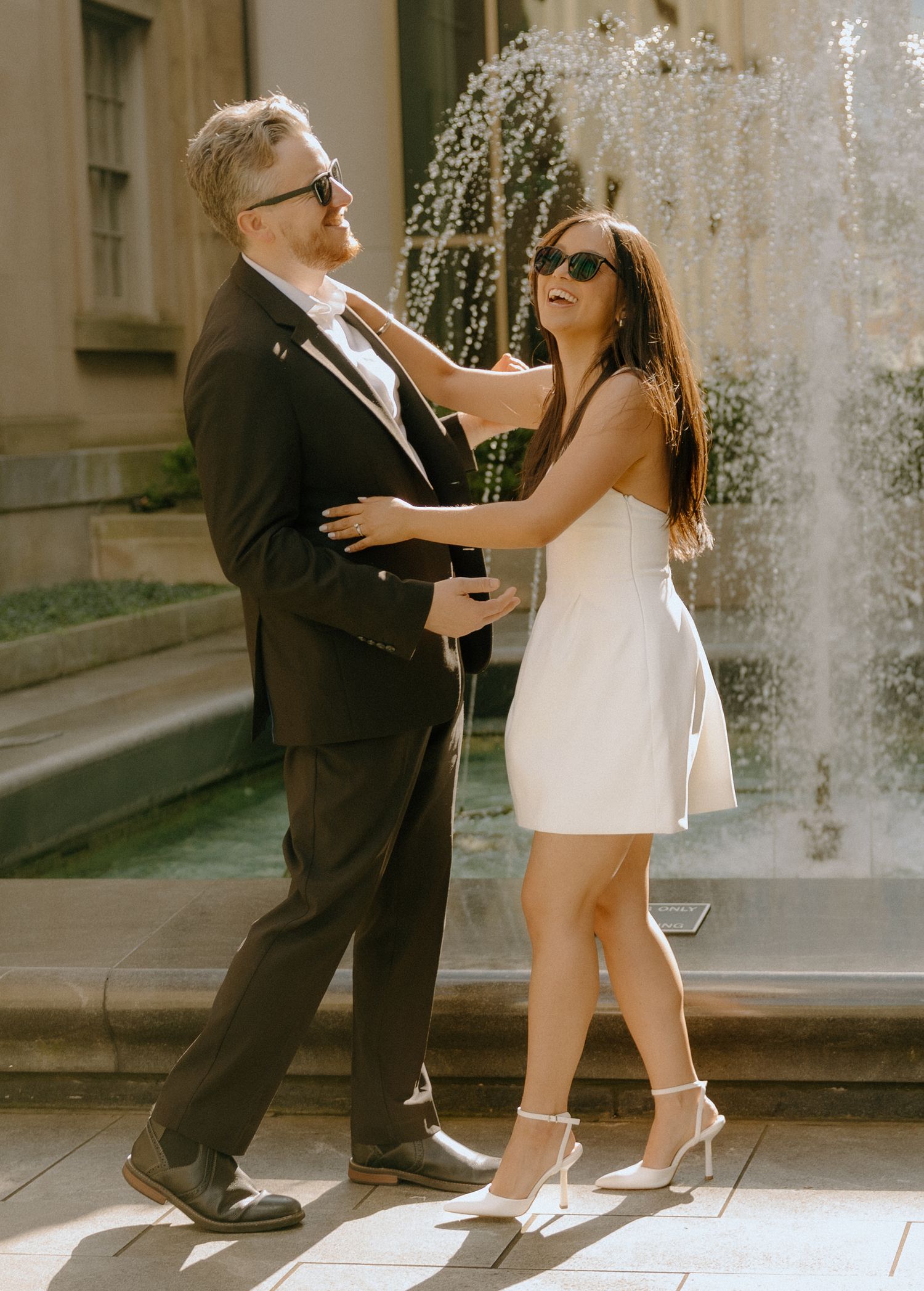 Romantic dance sequence captured in vintage style near an ornate fountain.