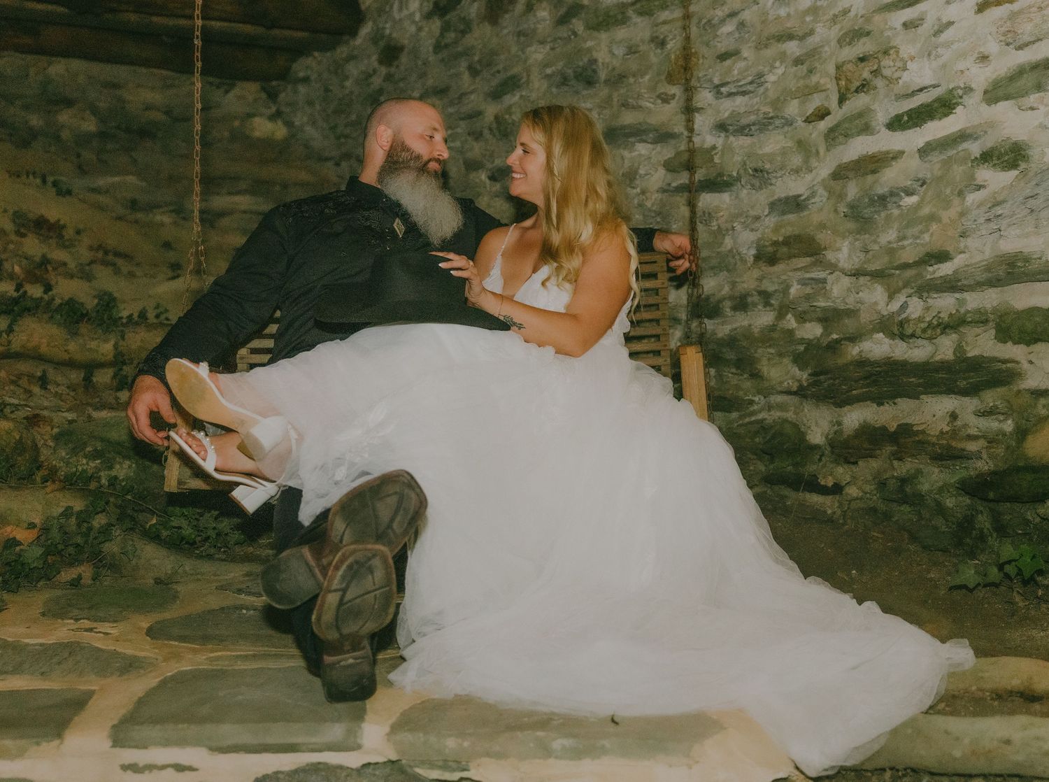 A romantic wedding photoshoot in a rustic stone setting with flowing white dress details.
