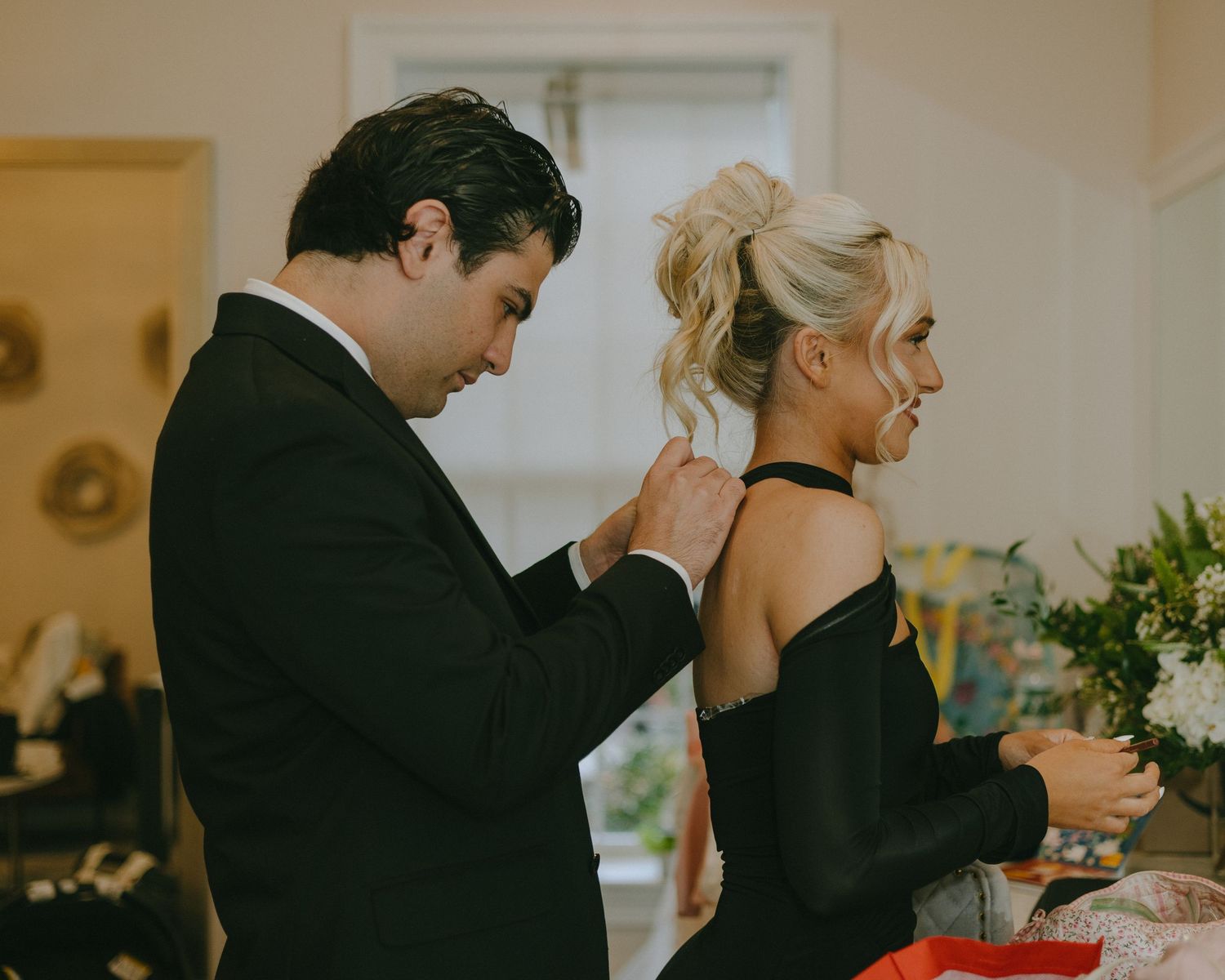 A couple in formal attire dance together at an elegant indoor event with warm lighting and romantic atmosphere.