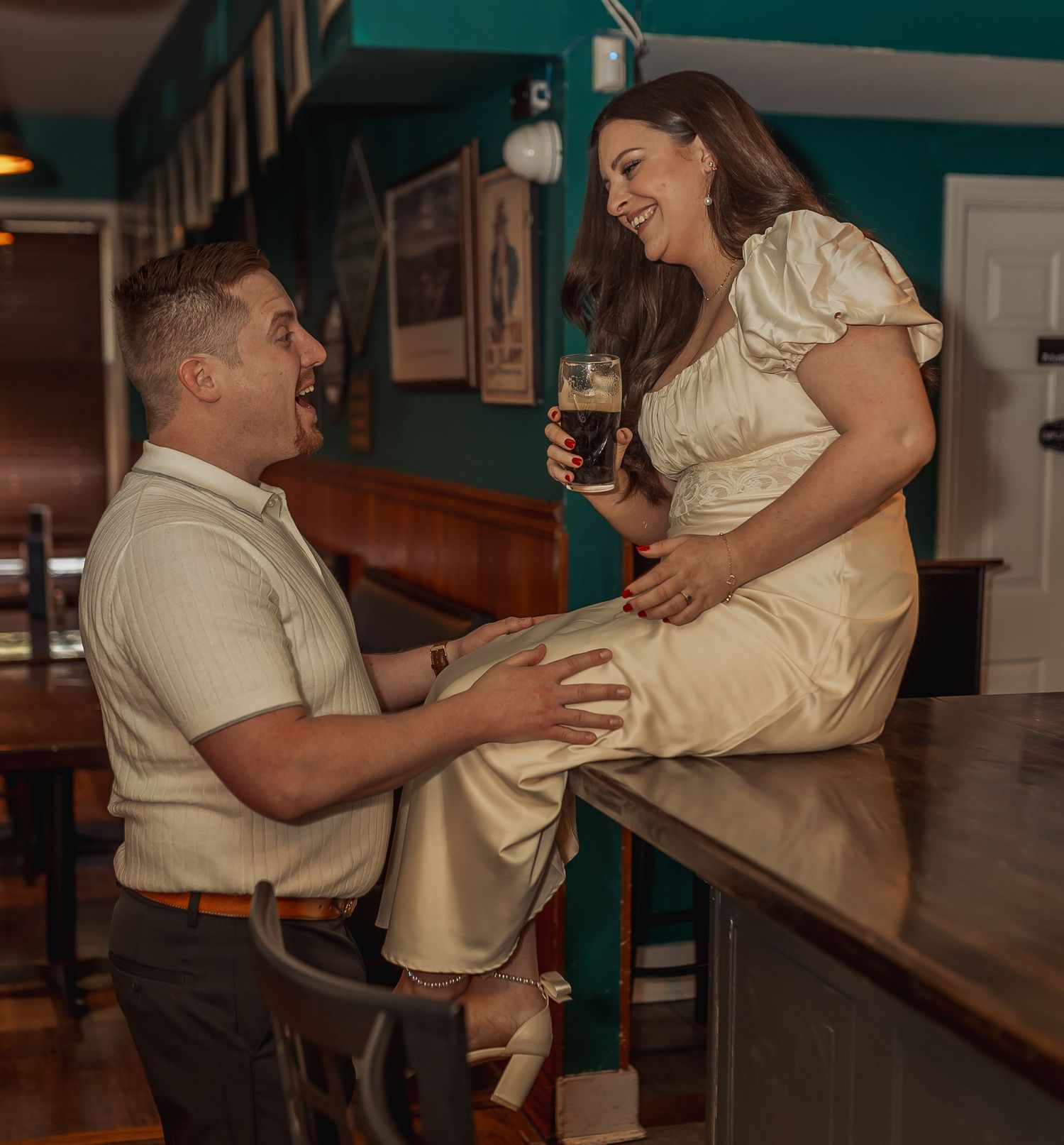 A playful scene unfolds at a retro bar with booth seating and moody lighting.