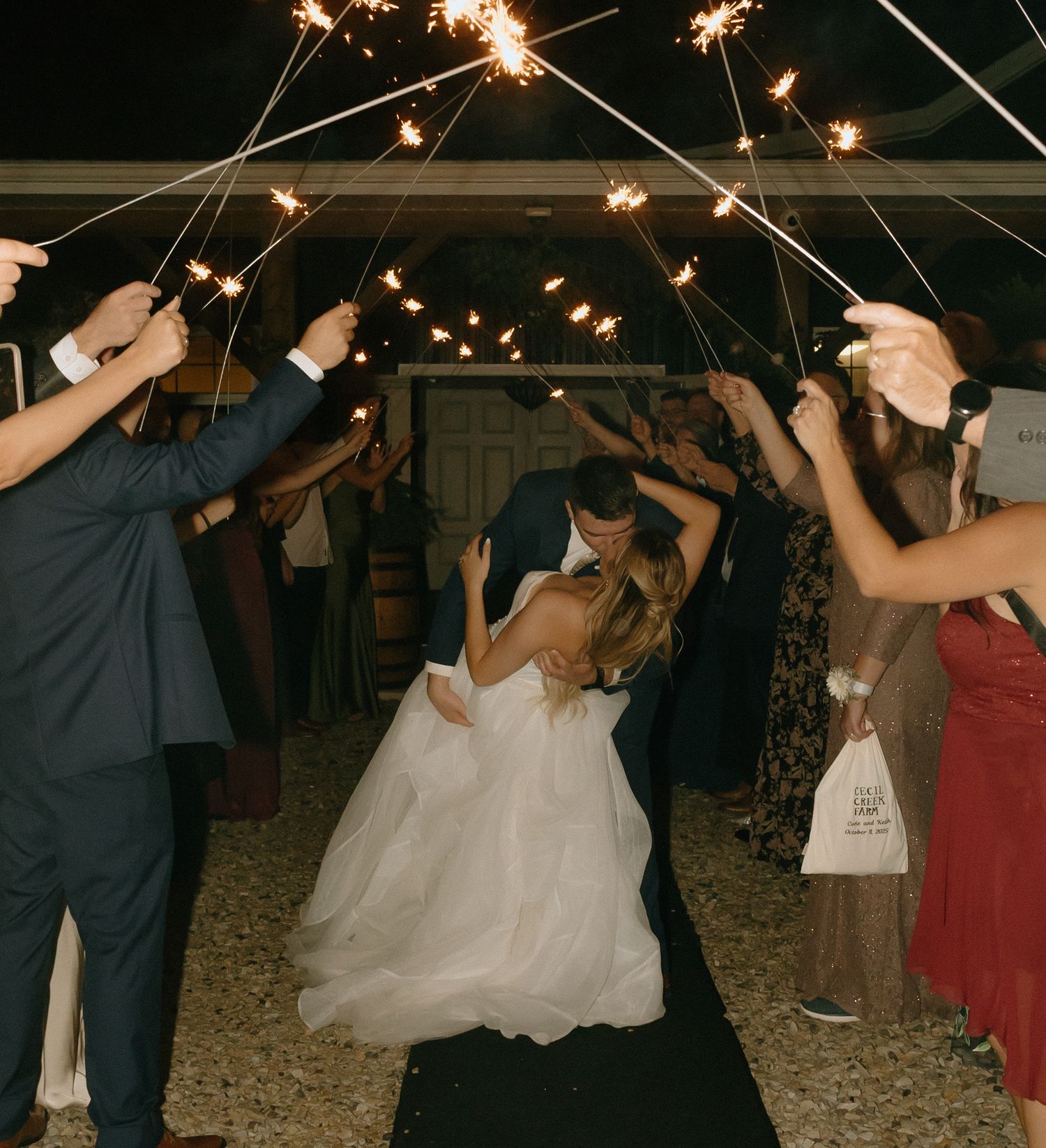 Wedding sparklers create magical light trails as couples dance together at an evening outdoor reception.