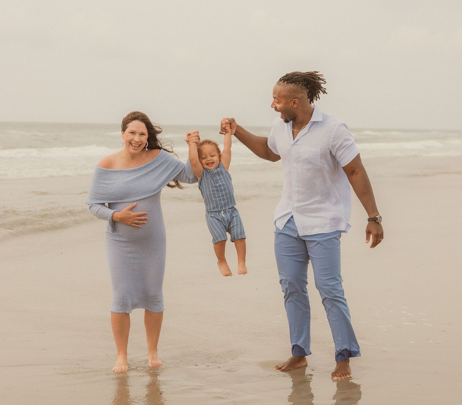 A couple plays and laughs together while splashing in the ocean waves at the beach.