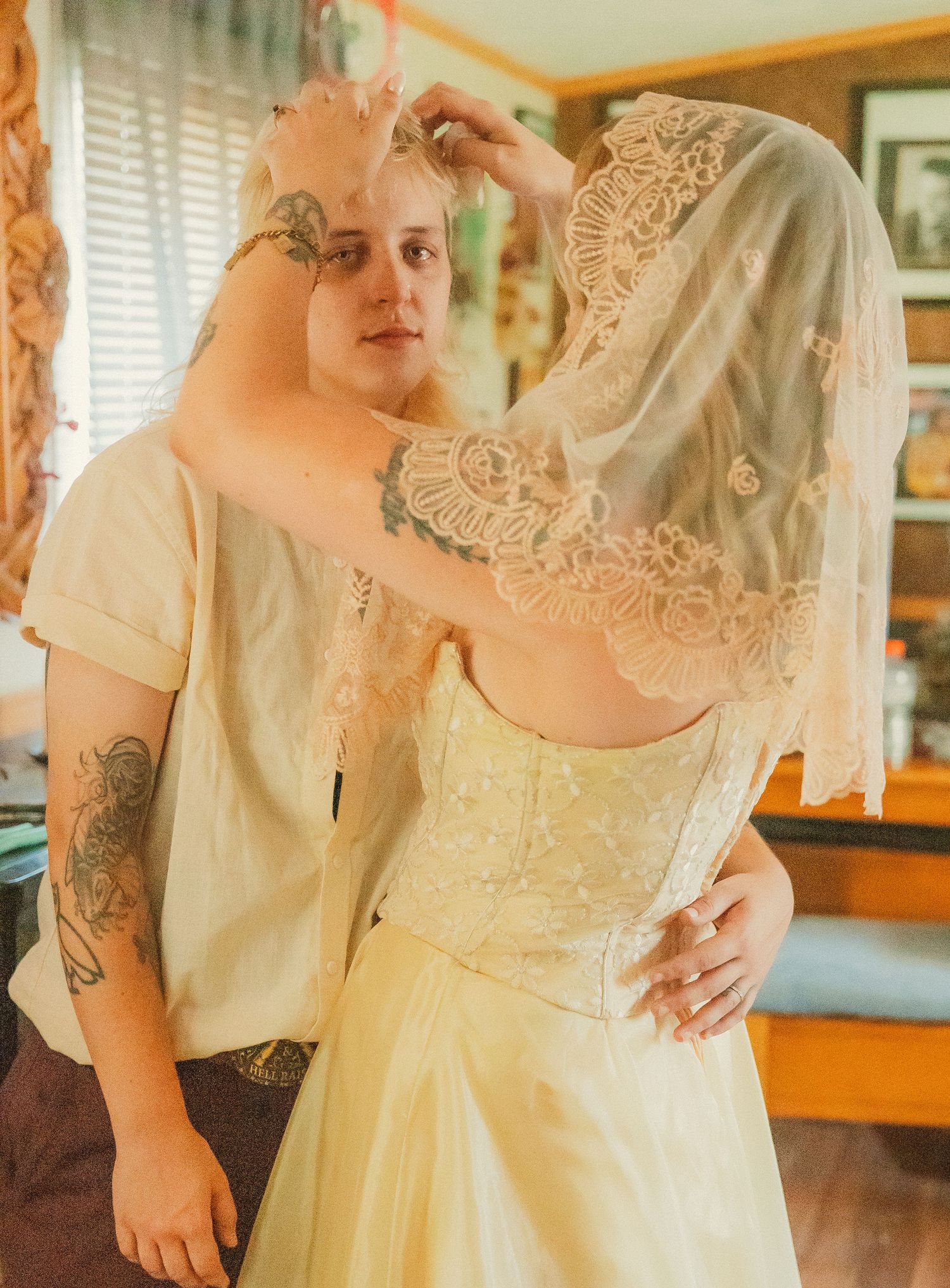 Close-up details of a cream-colored vintage lace wedding dress with delicate embroidery patterns.