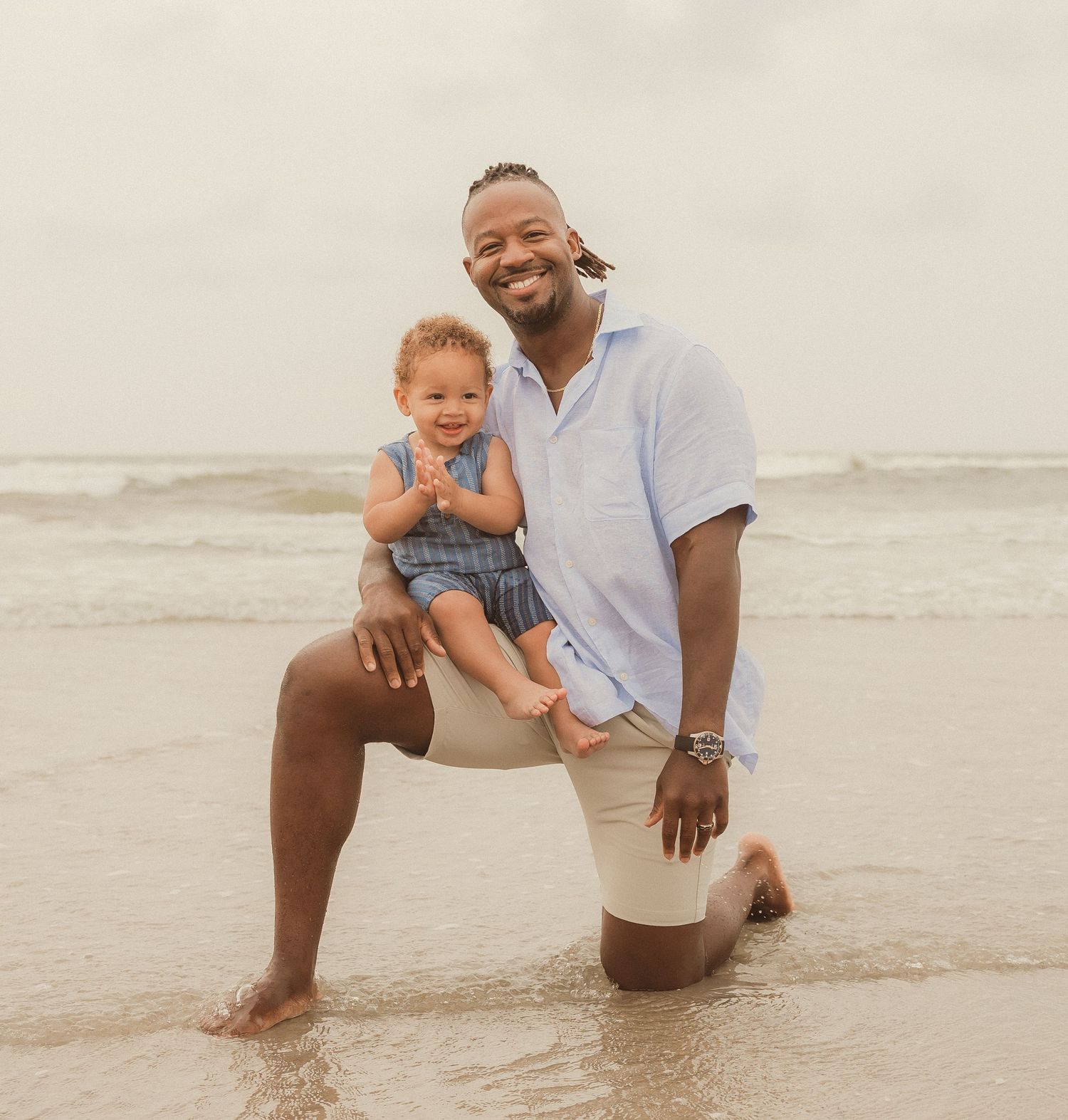 Playful family moment captured on sandy beach during sunset photoshoot.
