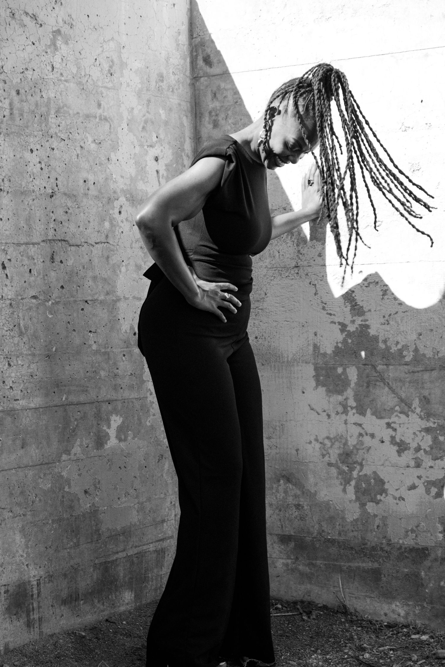 Dramatic black and white sequence showing movement against a textured wall.