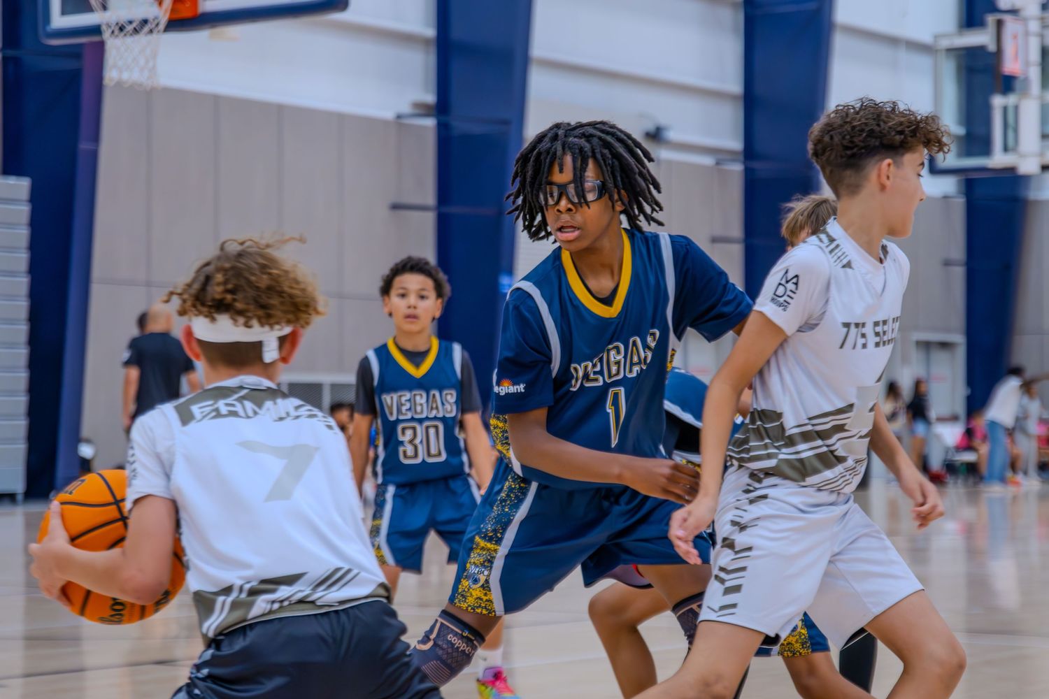 Youth basketball players in action during indoor game.