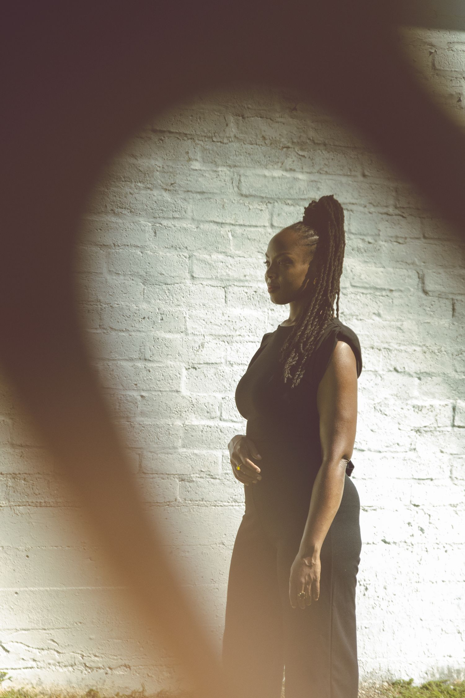 Silhouetted figure poses in sequence against white brick wall with dramatic lighting.