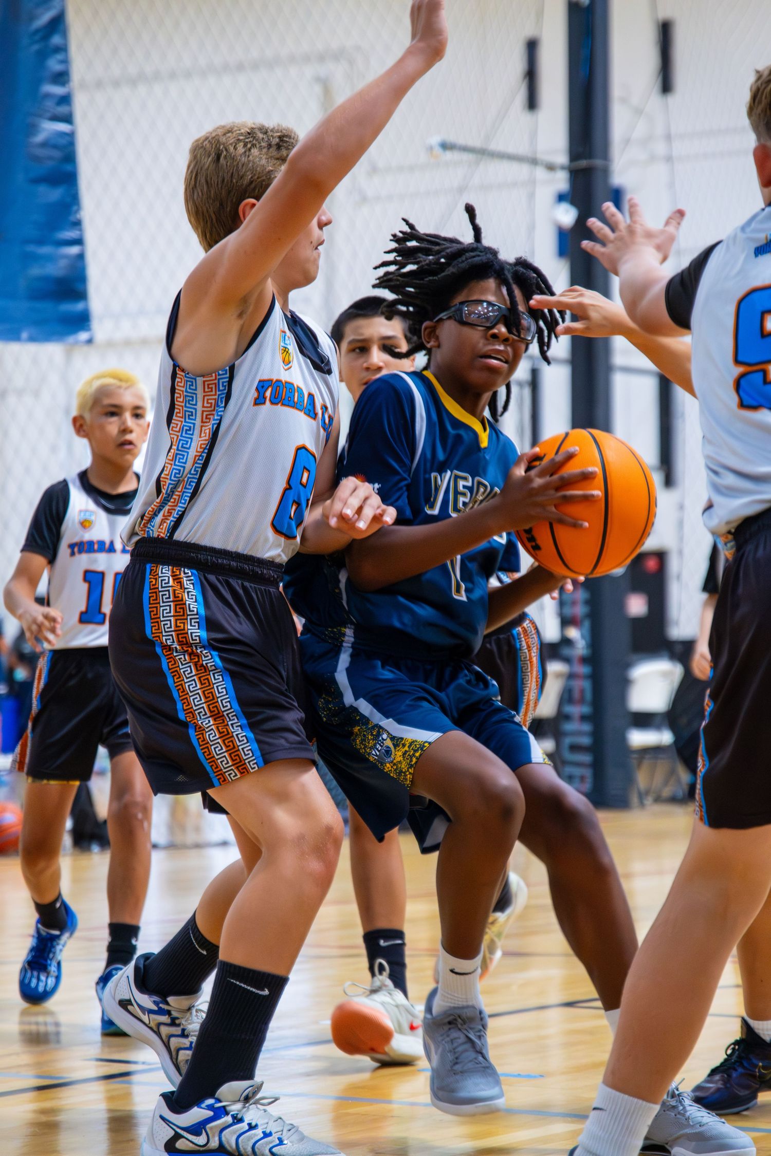 Young basketball players practice dribbling drills in a sports gym during youth training.