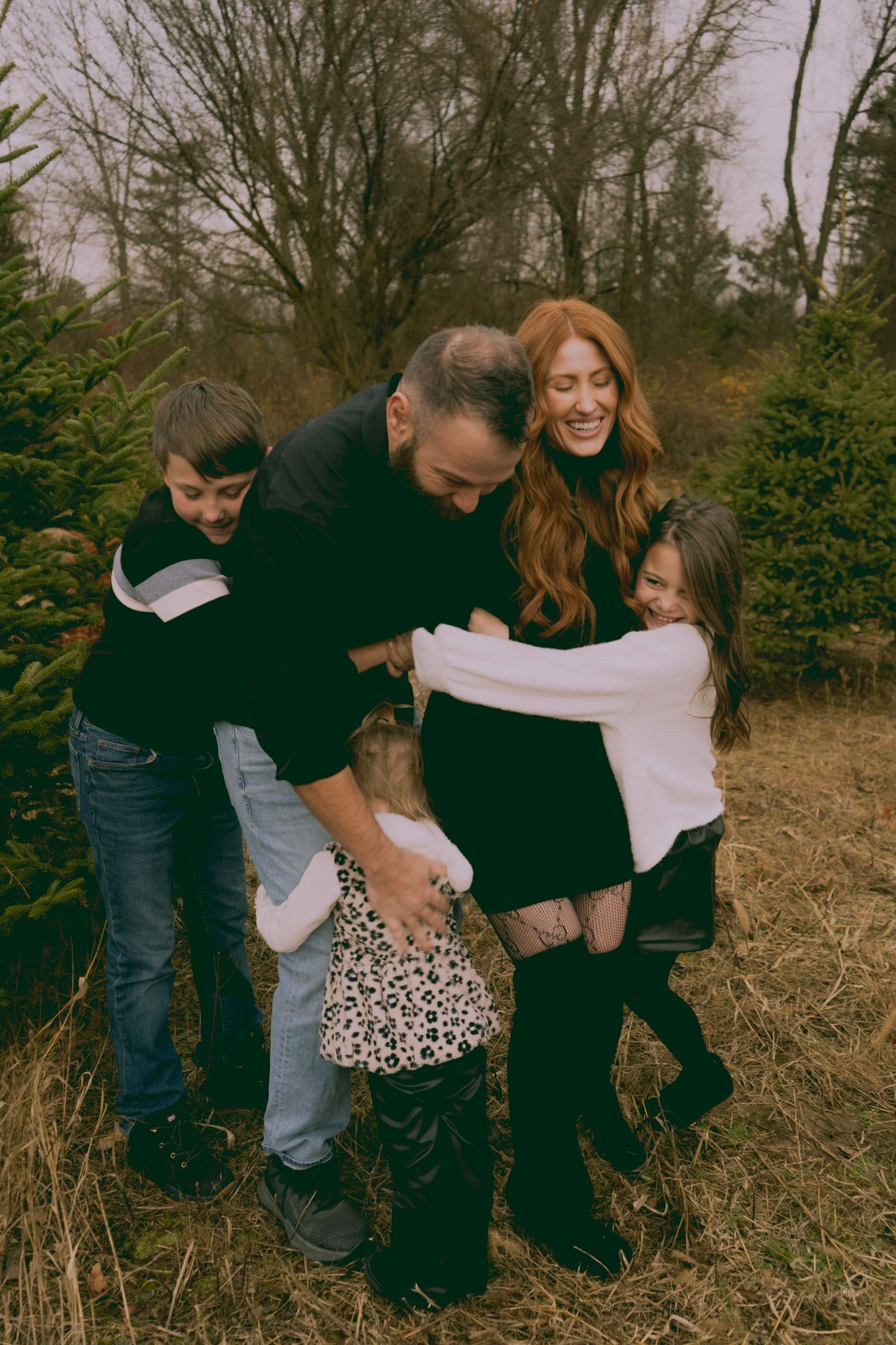 Candid lifestyle sequence showing family sitting and laughing together outside in a field during autumn.