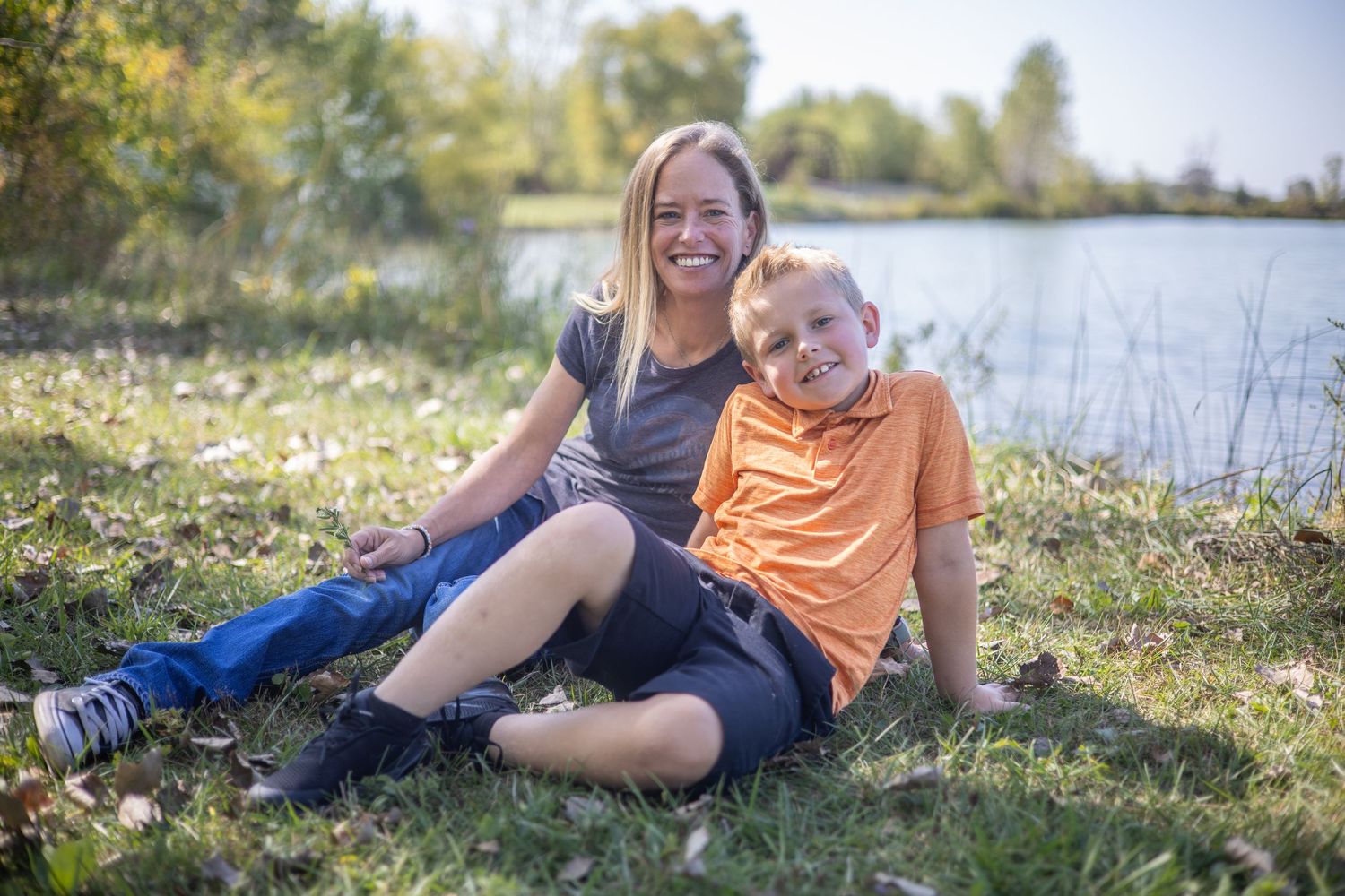 A joyful outdoor portrait session by a serene lake on a sunny day. During Family session