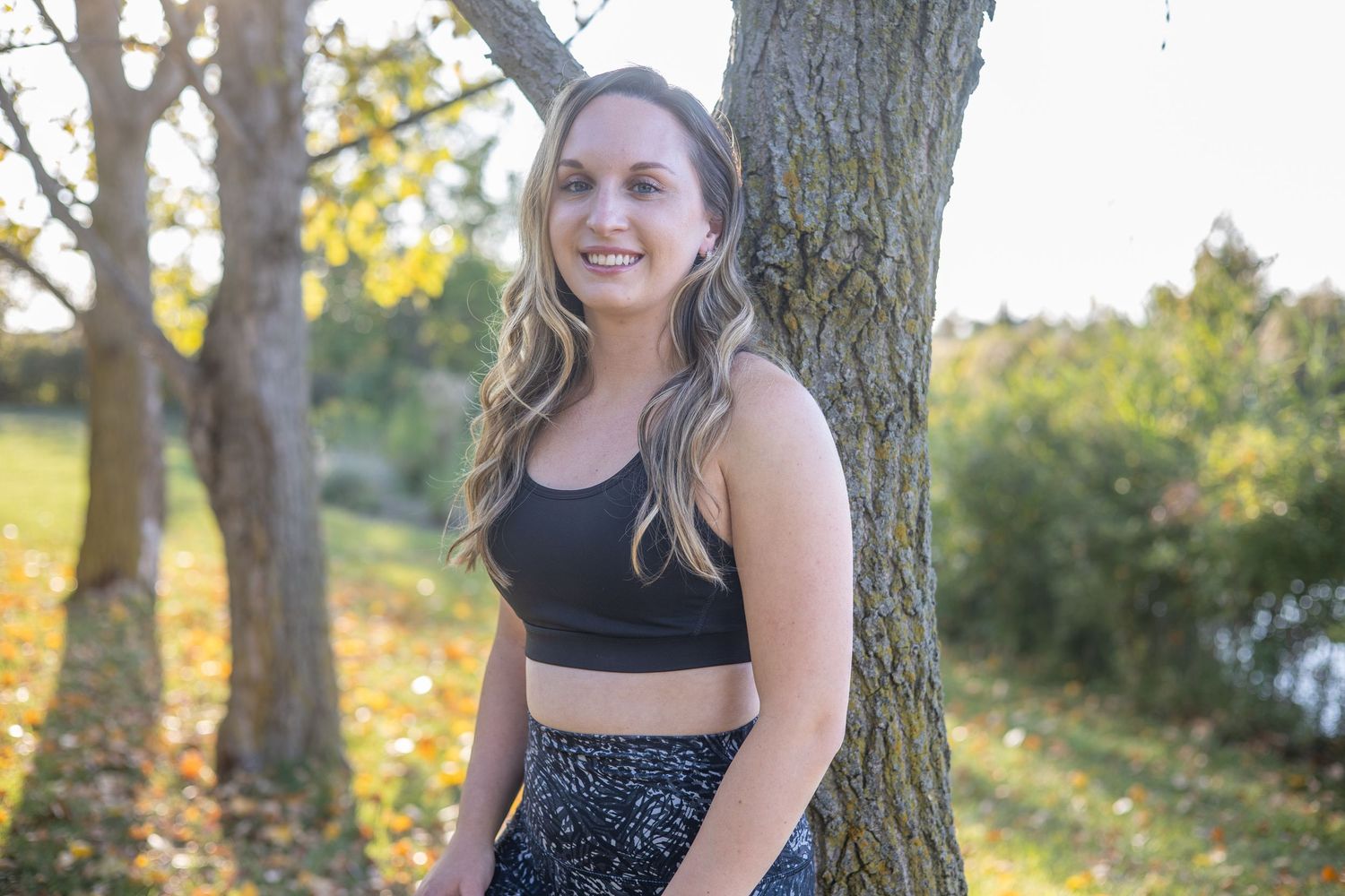 Woman practicing yoga poses in nature during golden hour sunset with trees in background.