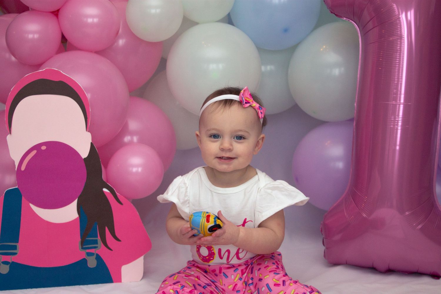 Pink and white balloons create a festive backdrop for a birthday celebration.