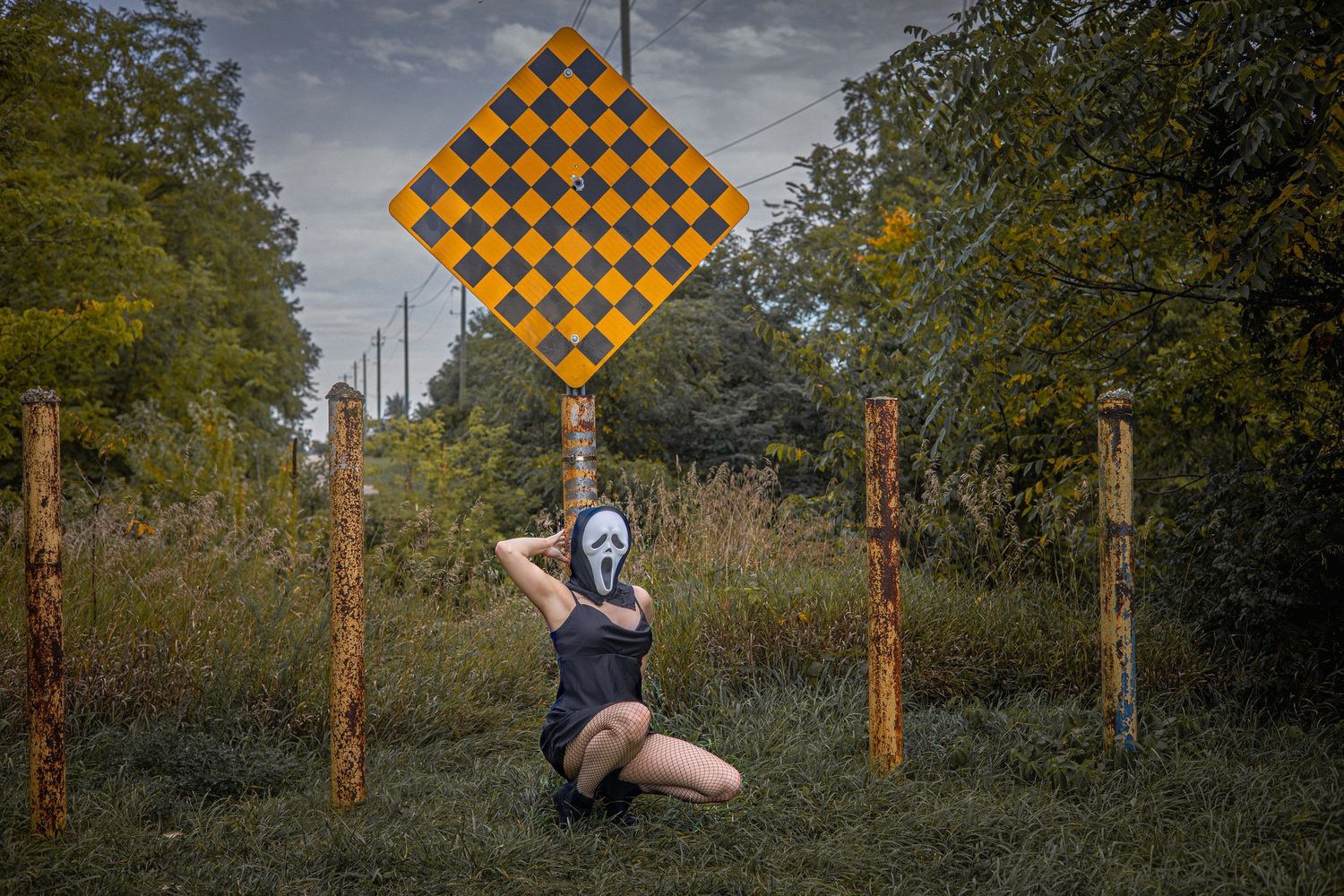 Orange and black checkered flags displayed in an outdoor natural setting with trees and foliage.