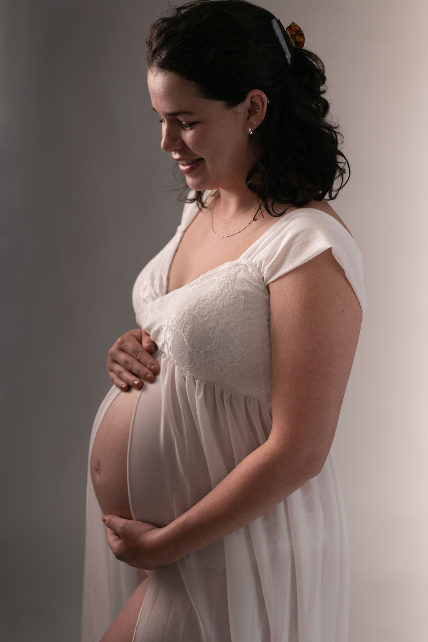 A series of artistic maternity photos showing a pregnant woman in a white dress against a neutral background.