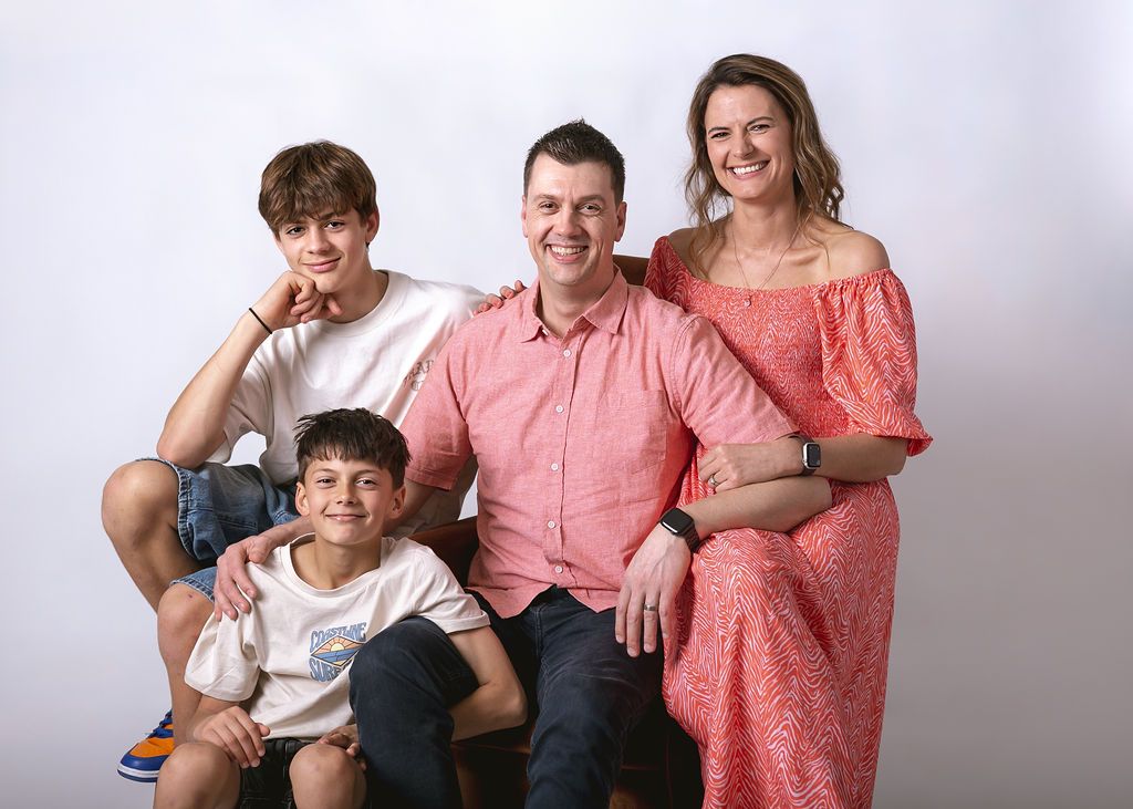Family photo session in coordinated coral and white outfits against light studio background at Gabriella Aranky Photography studio, Auckland