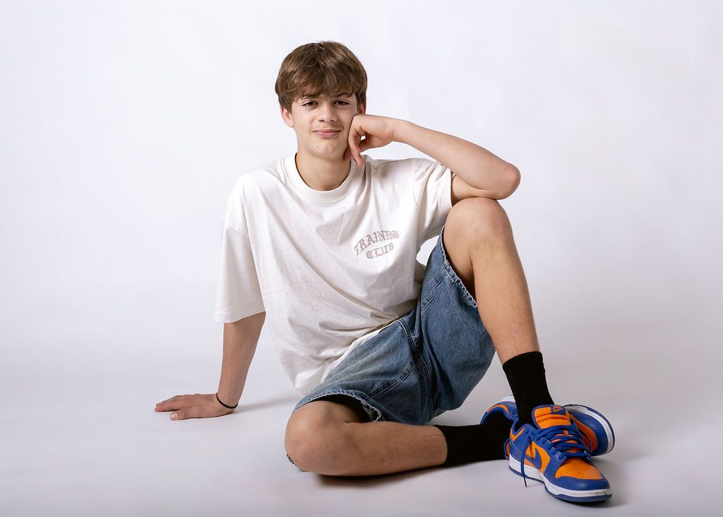 Casual studio poses of young person in white t-shirt and jeans on light background at Gabriella Aranky Photography studio, Auckland.