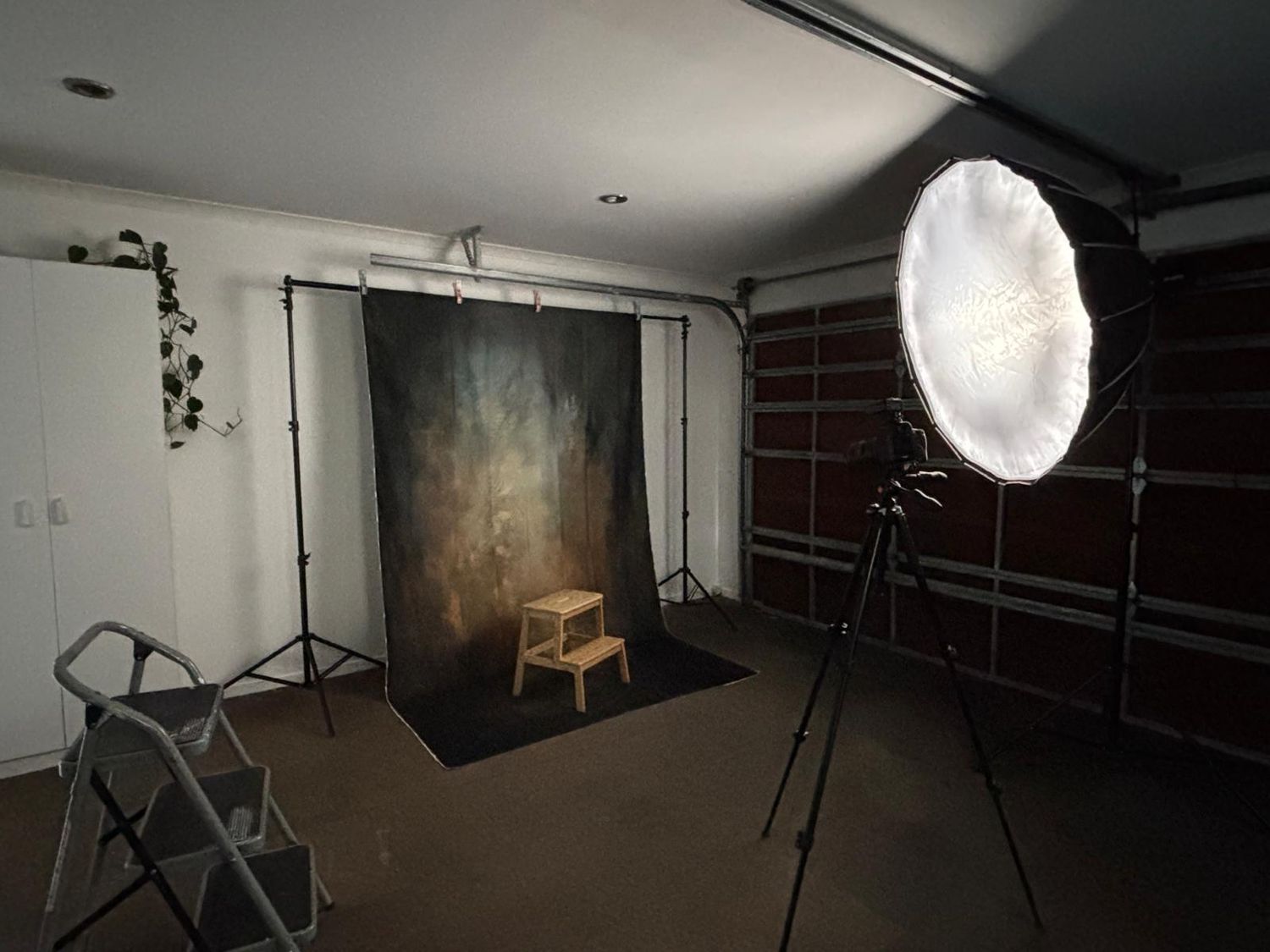 Professional photo studio interior with lighting equipment and dark backdrop setup.