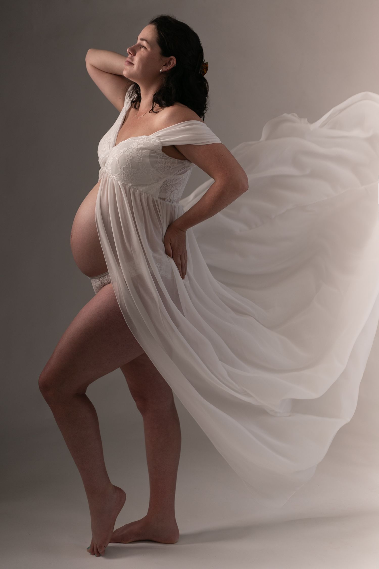 Artistic photo series showing dancer in flowing white dress performing expressive movements against gray backdrop.