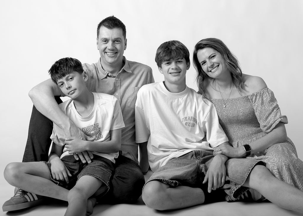 Studio family portrait series with everyone sitting down in casual poses at Gabriella Aranky Photography studio, Auckland.