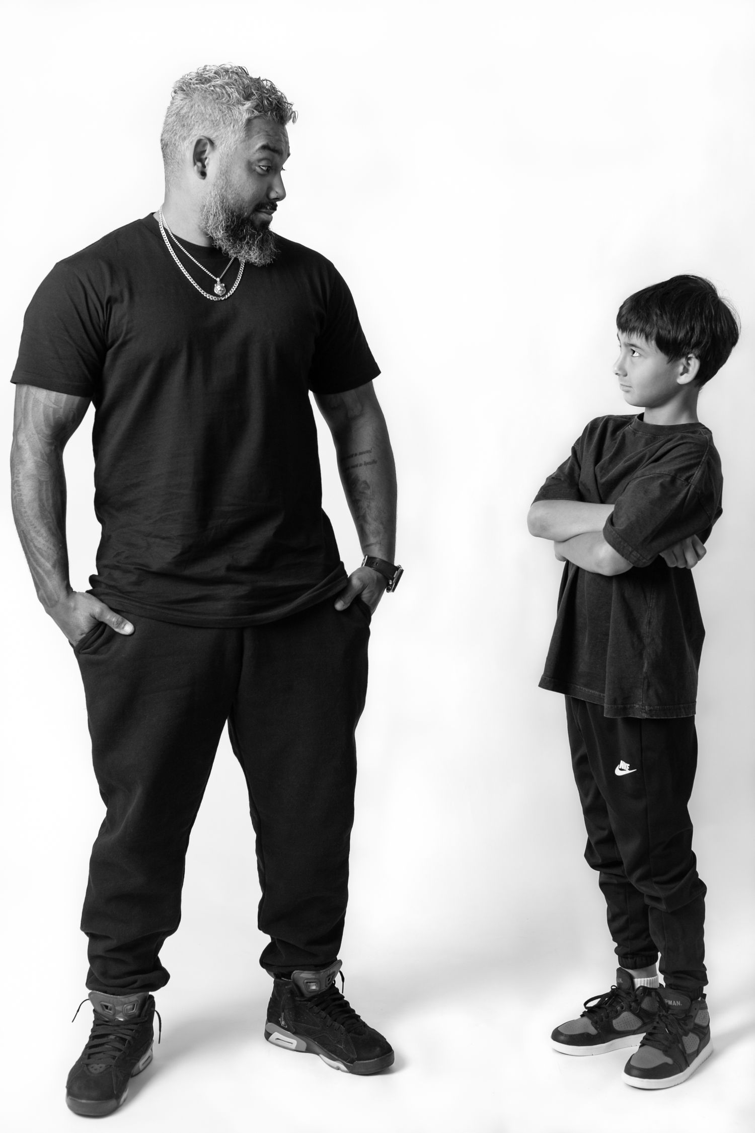 Black and white photo series showing different poses of a person in casual dark clothing against a white backdrop.