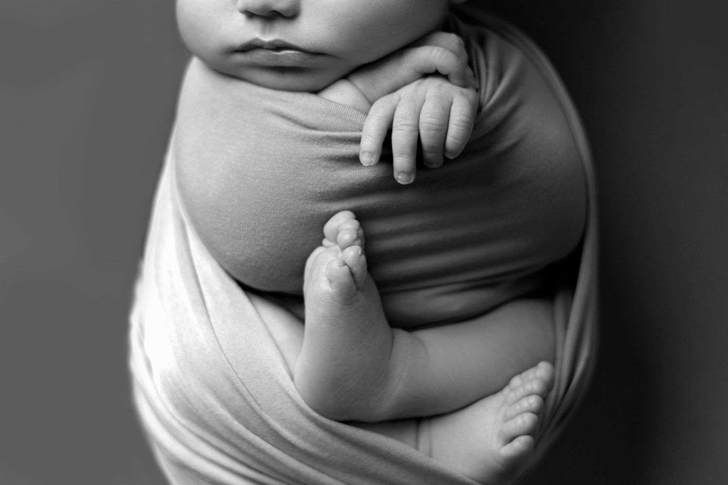 A series of black and white close-up photographs showing a pregnant woman's growing belly during different stages of pregnancy.