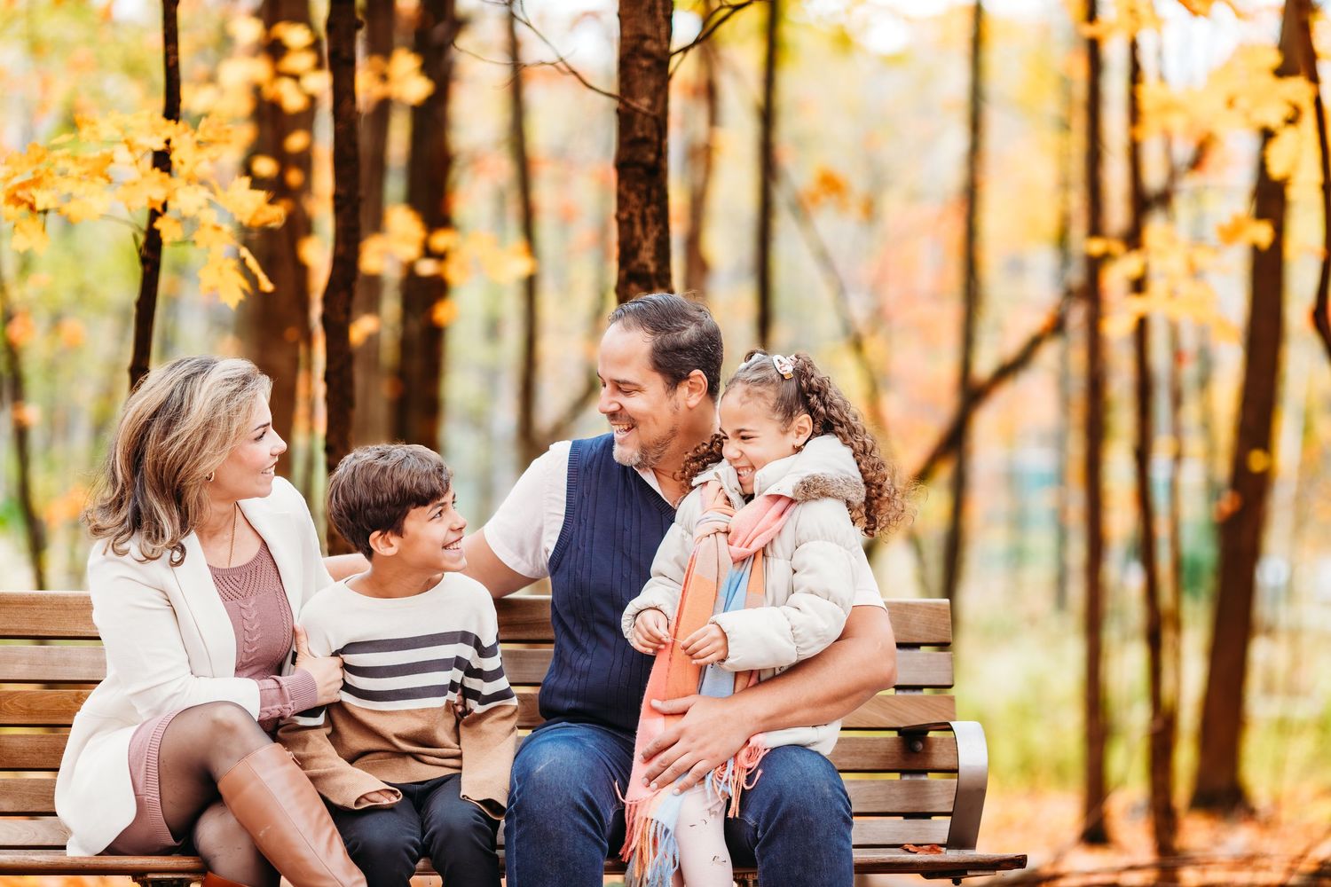 Des moments de famille spontanés, capturés sur des bancs en bois dans une forêt d'automne baignée de soleil.