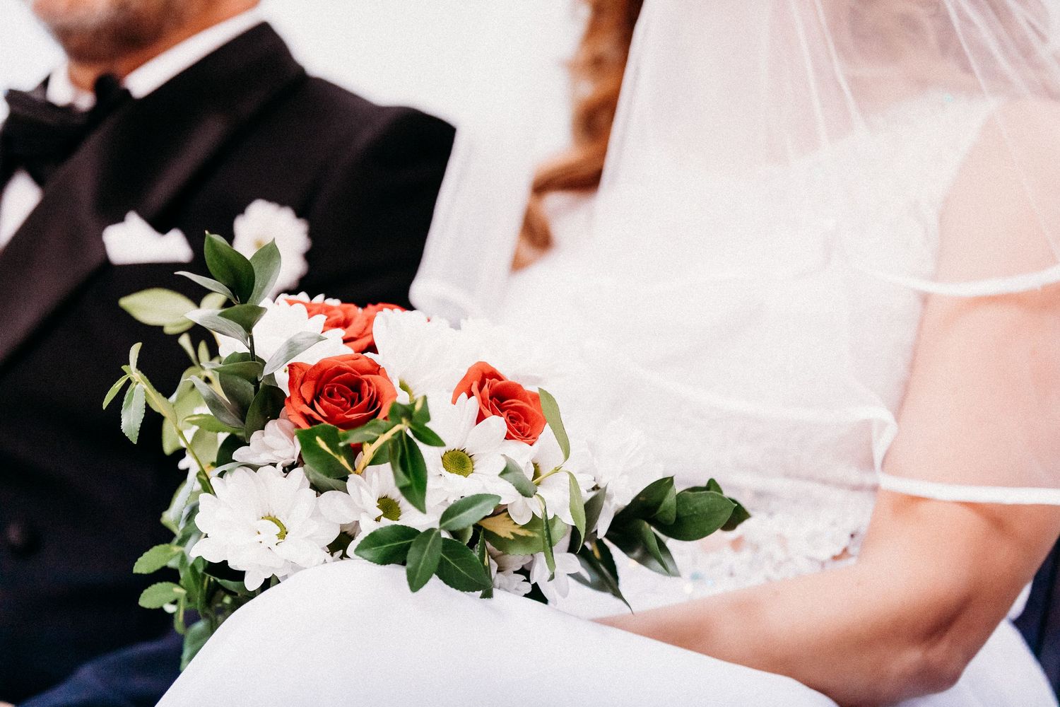 Une scène de mariage romantique avec des bouquets de fleurs blanches et un décor élégant.