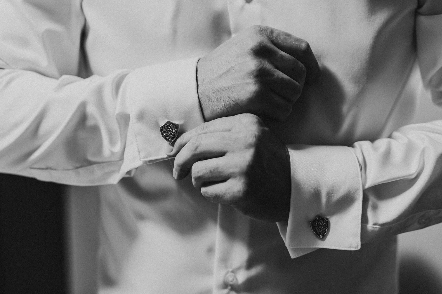 Close-up details of formal attire buttons and cuffs in black and white.