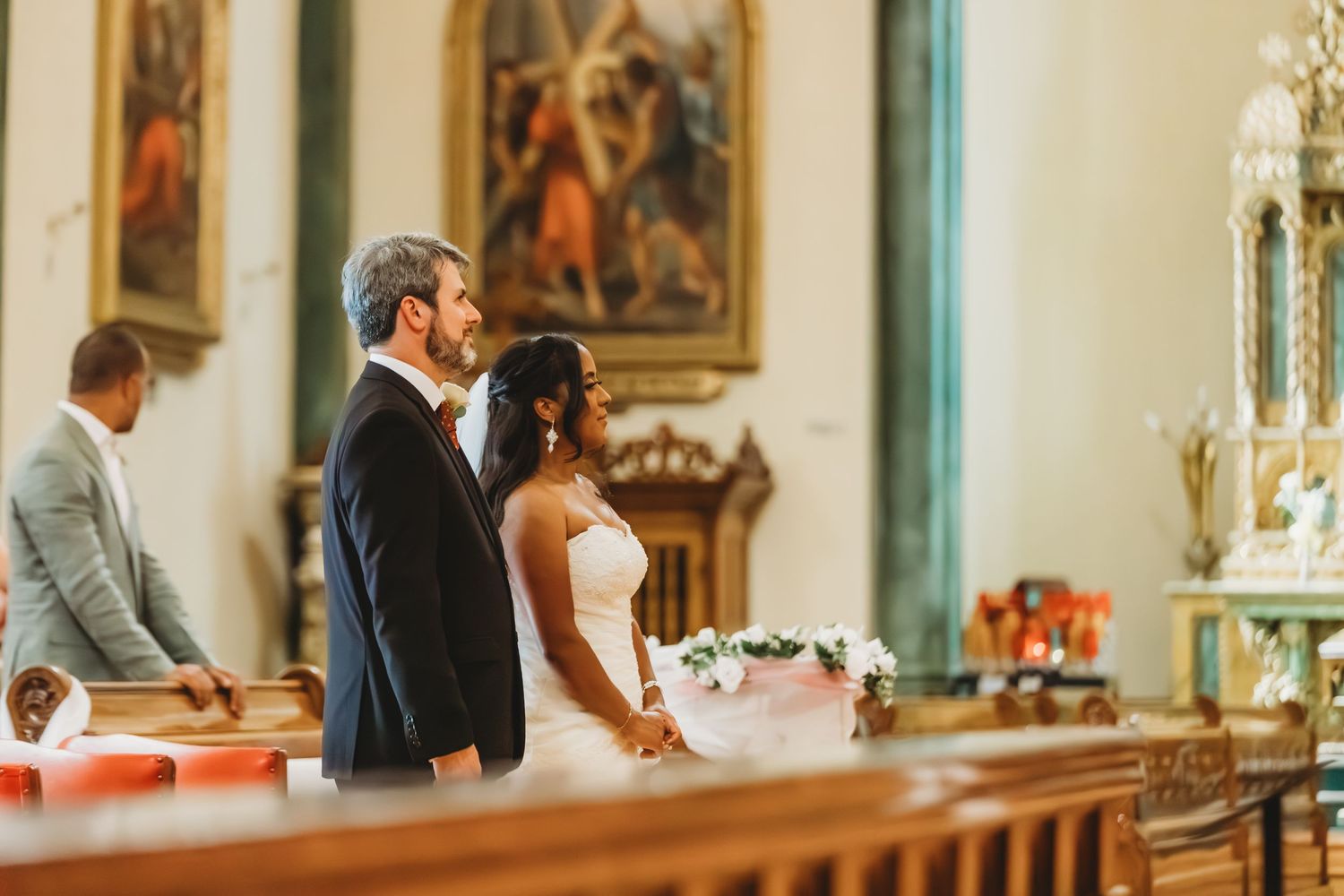 Cérémonie de mariage traditionnelle à l'église, avec des œuvres d'art et un décor religieux ornementés.