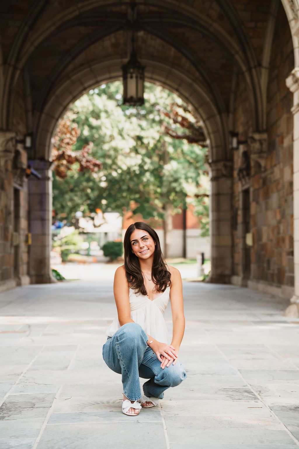 A series of photos showing someone sitting in a stone archway corridor wearing jeans and casual attire.