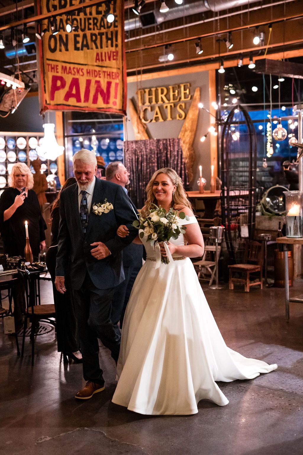 Wedding celebration inside an industrial-style venue with exposed brick walls and vintage signage.