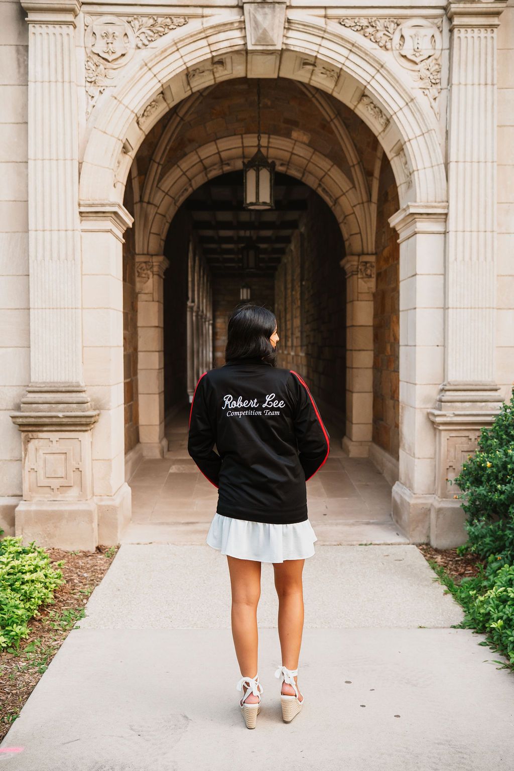 Walking through an ornate stone archway with classical architectural details and columns.