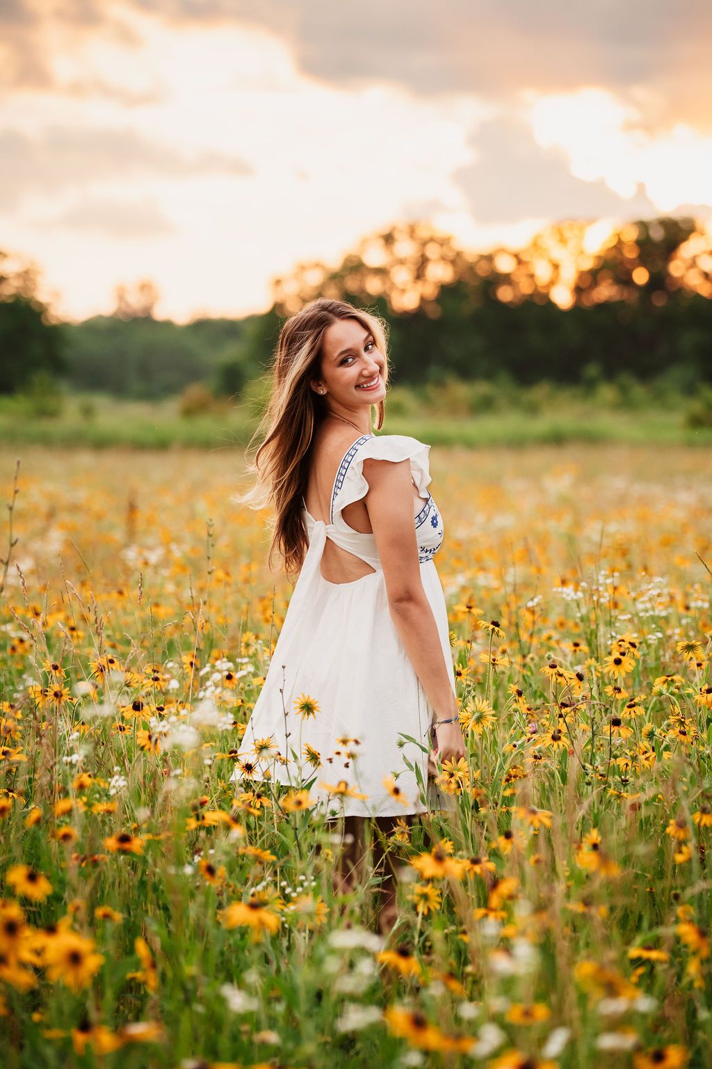 A white sundress twirls through a golden wildflower meadow at sunset creating a dreamy summer scene.
