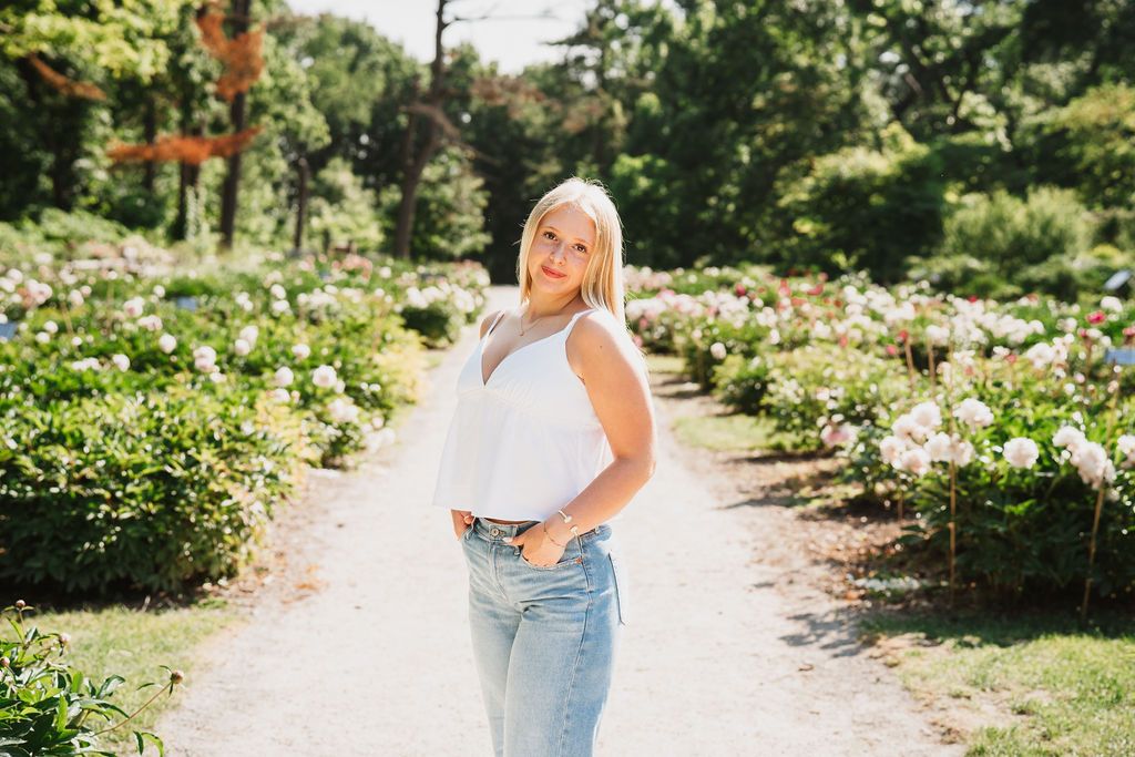 A summer portrait session in a lush garden setting with purple flowers and stone steps.