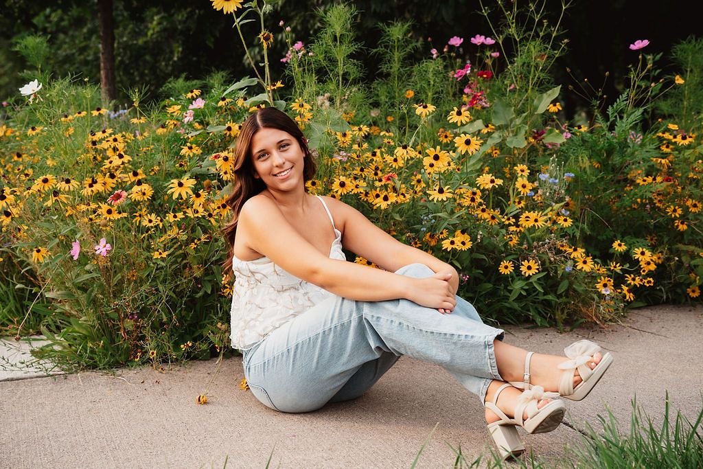Casual outdoor portrait among colorful wildflowers and garden blooms. Pickney Senior Photos, wildflower senior photos