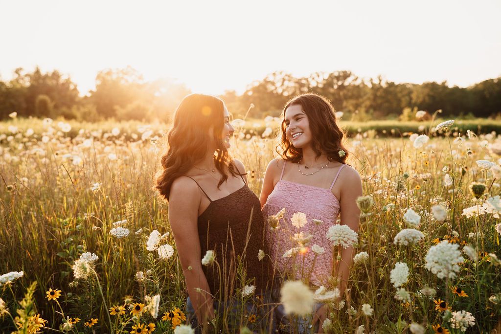A dreamy golden hour photoshoot in a wildflower meadow with soft sunlight filtering through the tall grass.