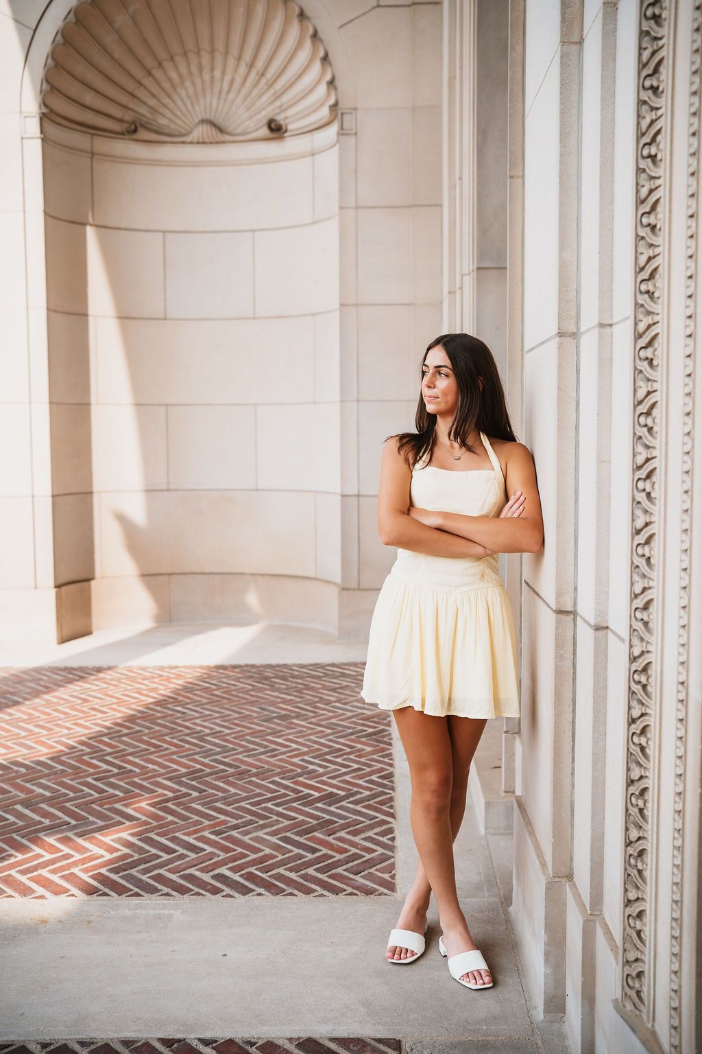 White columns and brick walkway create an elegant architectural setting with soft natural lighting.