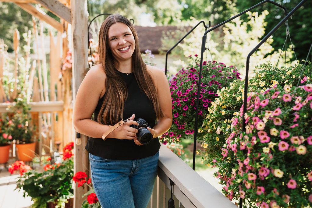 Outdoor photography session in a garden with blooming pink roses and greenery.