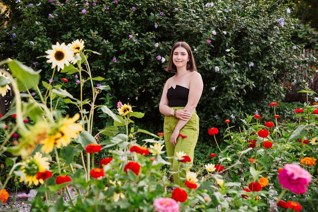 Colorful garden scene with red and yellow flowers blooming among lush green foliage.