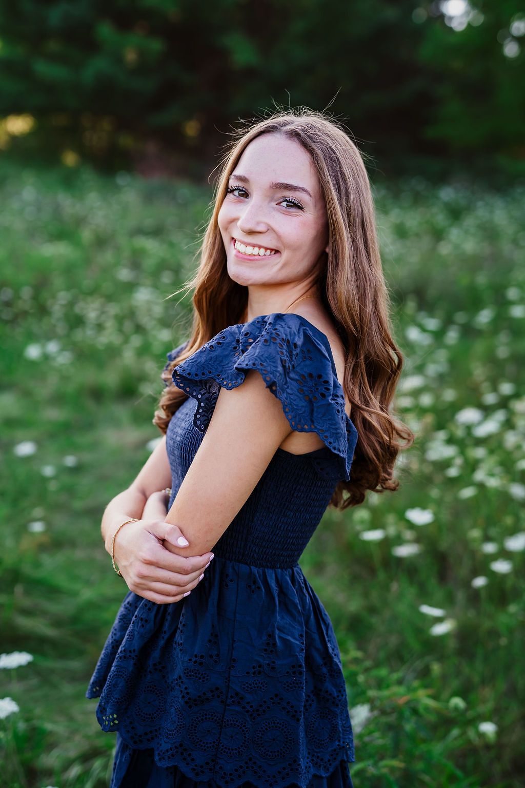 A sequence of joyful poses in a navy blue dress against a lush green garden background with wildflowers.