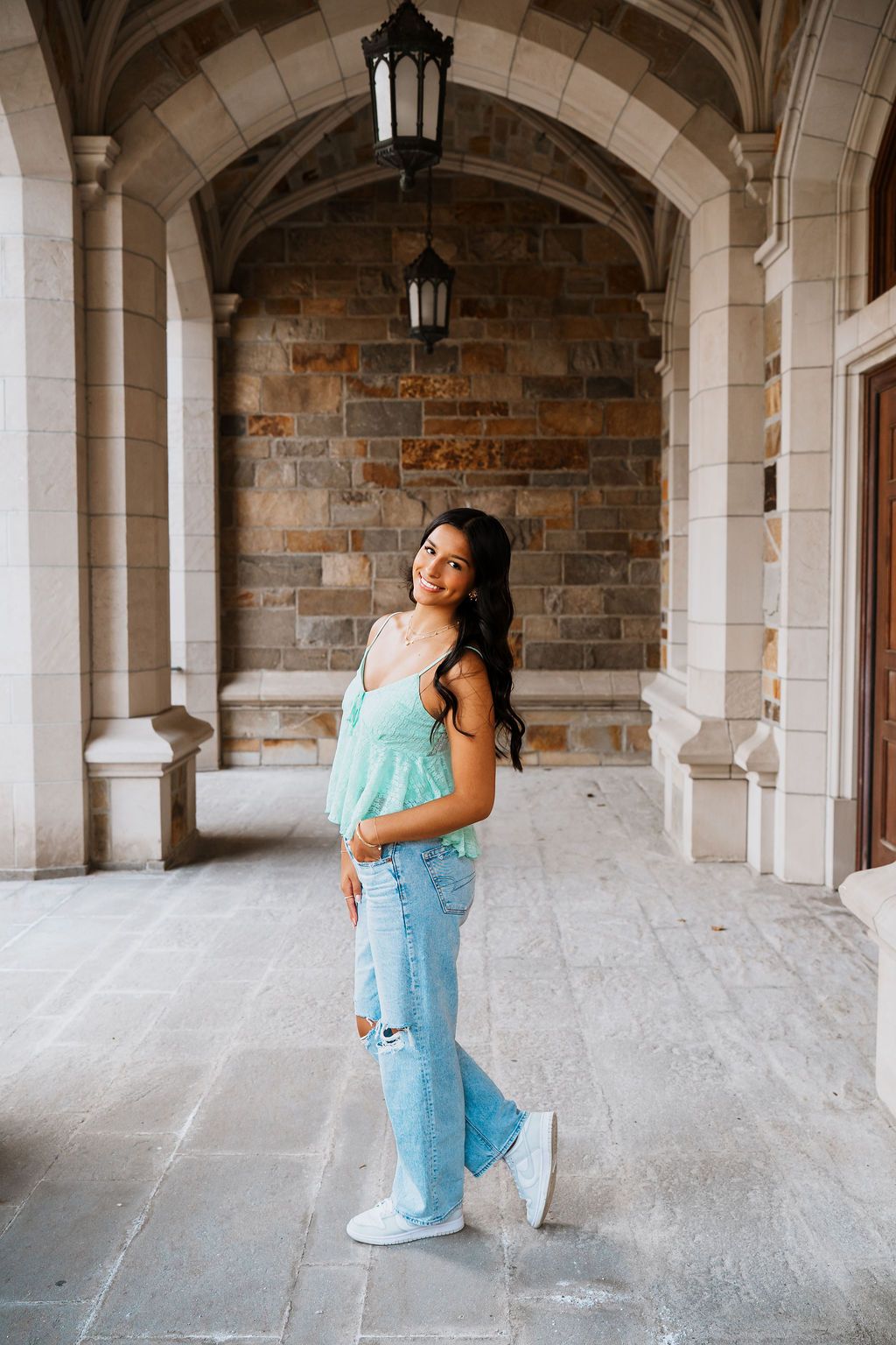 Playful poses captured under ornate stone archways with gothic architectural details.