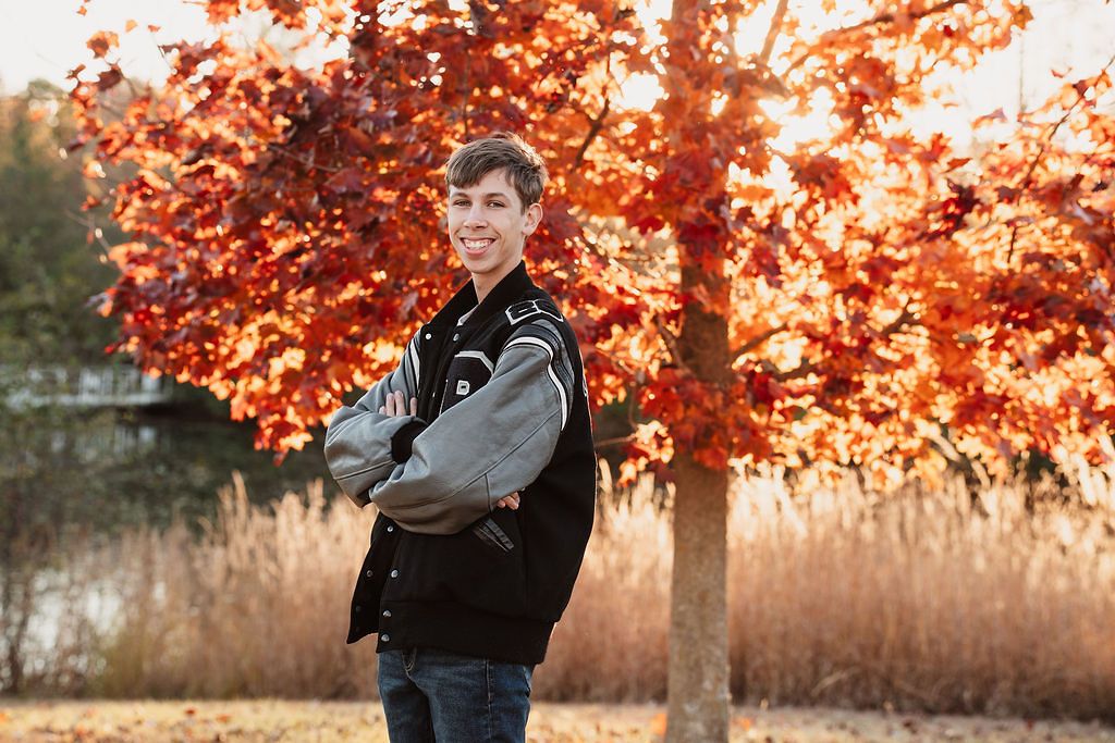 Autumn portrait session with vibrant orange foliage in the background at sunset. McClumpha Plymouth township park senior photos