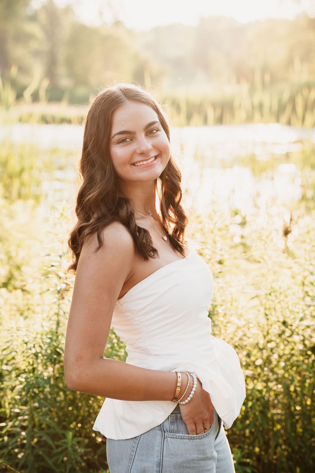 Romantic sunset photoshoot in a blooming meadow with soft backlit glow and casual summer style.