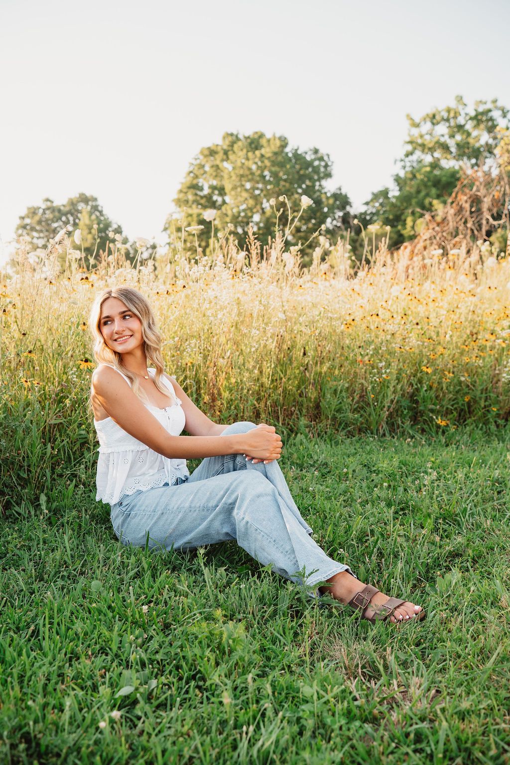 Casual outdoor portrait session in a grassy field during golden hour.