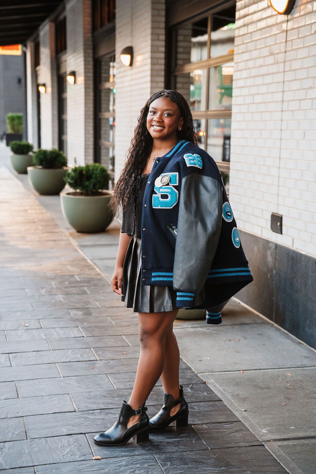 Street style photos showcasing a varsity-style jacket with blue lettering against an urban backdrop.